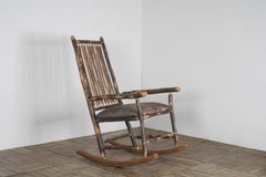 Silla mecedora americana antigua con respaldo de varilla y asiento de cuero con pátina envejecida