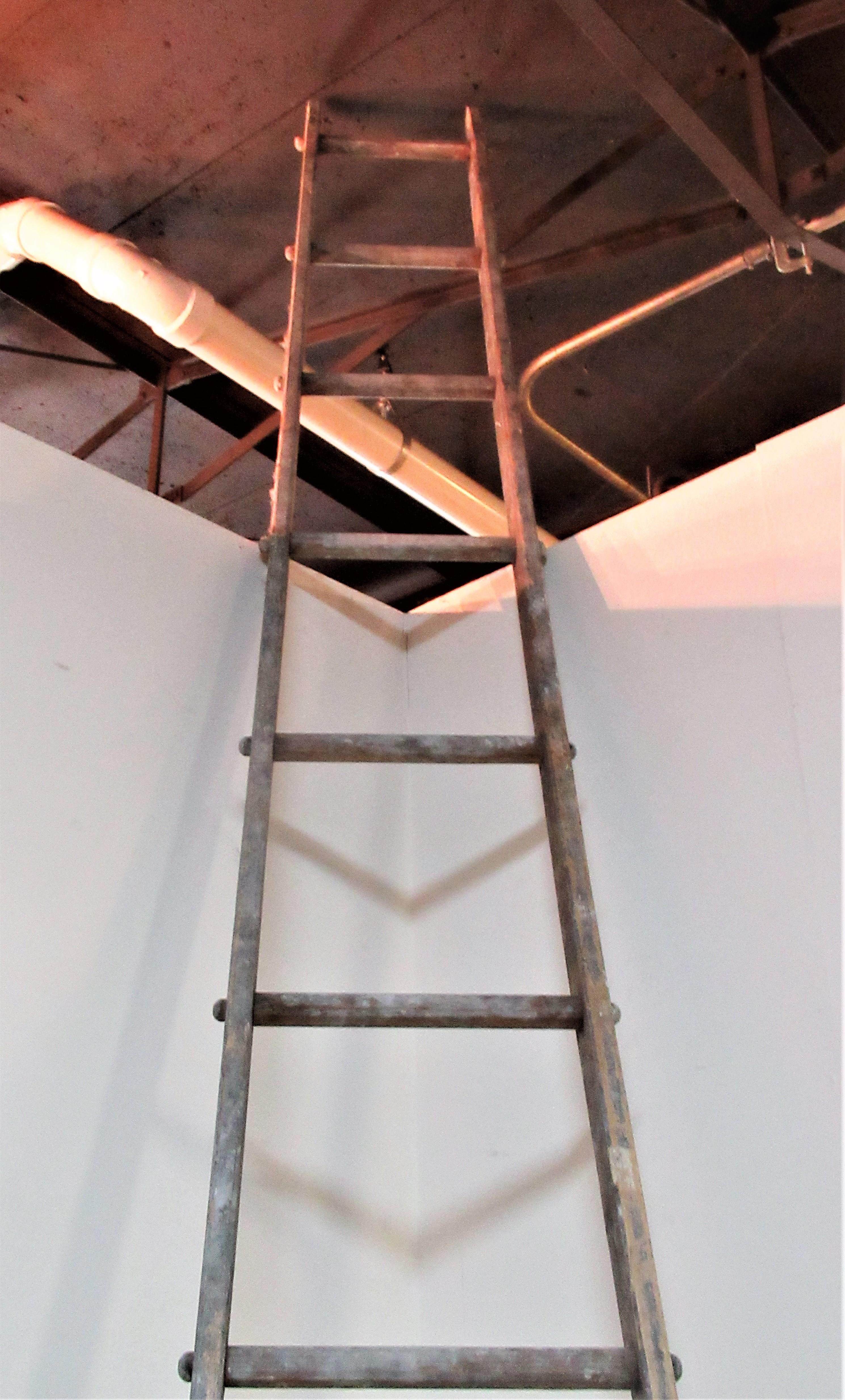 Antique signed wood and metal pinned (at rungs) apple picking orchard ladder in old weathered worn gray painted surface and a beautifully tapered splayed very tall form measuring 12 feet in height x 22