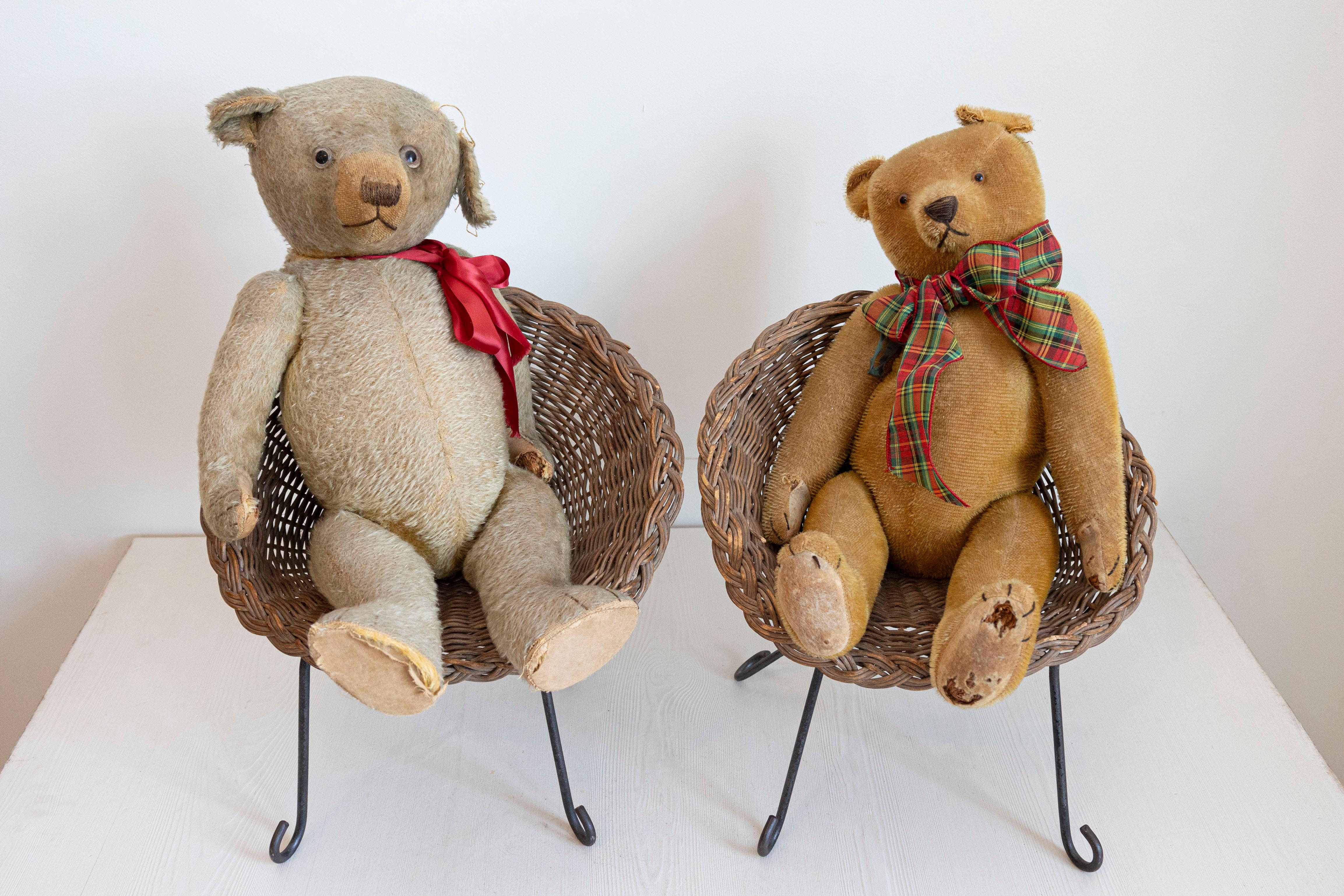 Two antique American teddy bears from the 20th century sitting in wicker chairs, priced and sold individually $495 each. Made in the USA during the 20th century, each teddy bear melts our hearts with its nicely weathered appearance revealing its