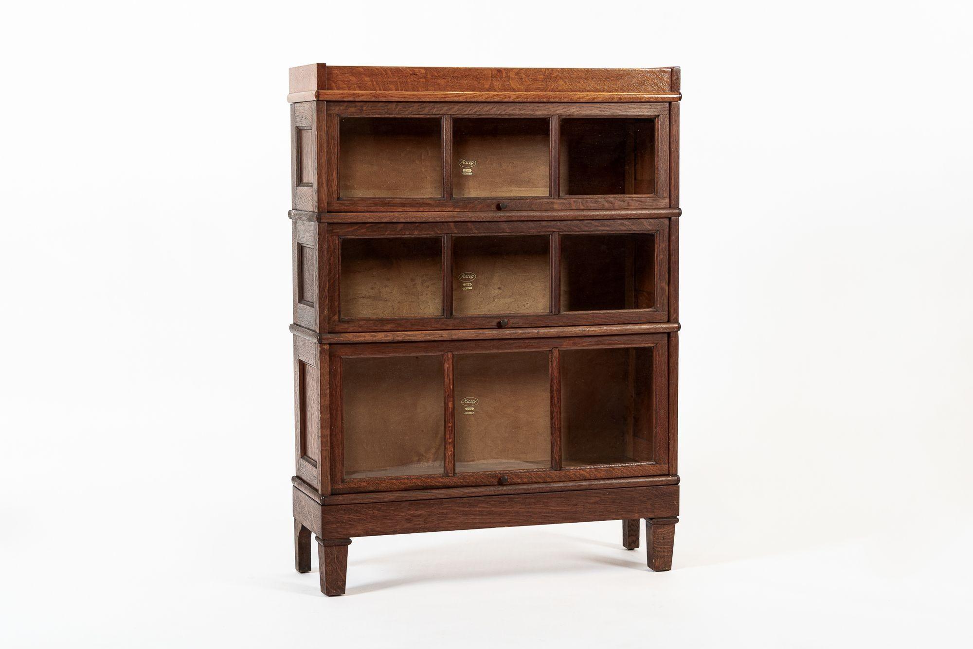 This antique mission style three stack wooden lawyer or barrister bookcase cabinet was made by Macey and is from the early 1900s. Expertly crafted from tiger oak wood, this modular bookshelf disassembles into five individual pieces including