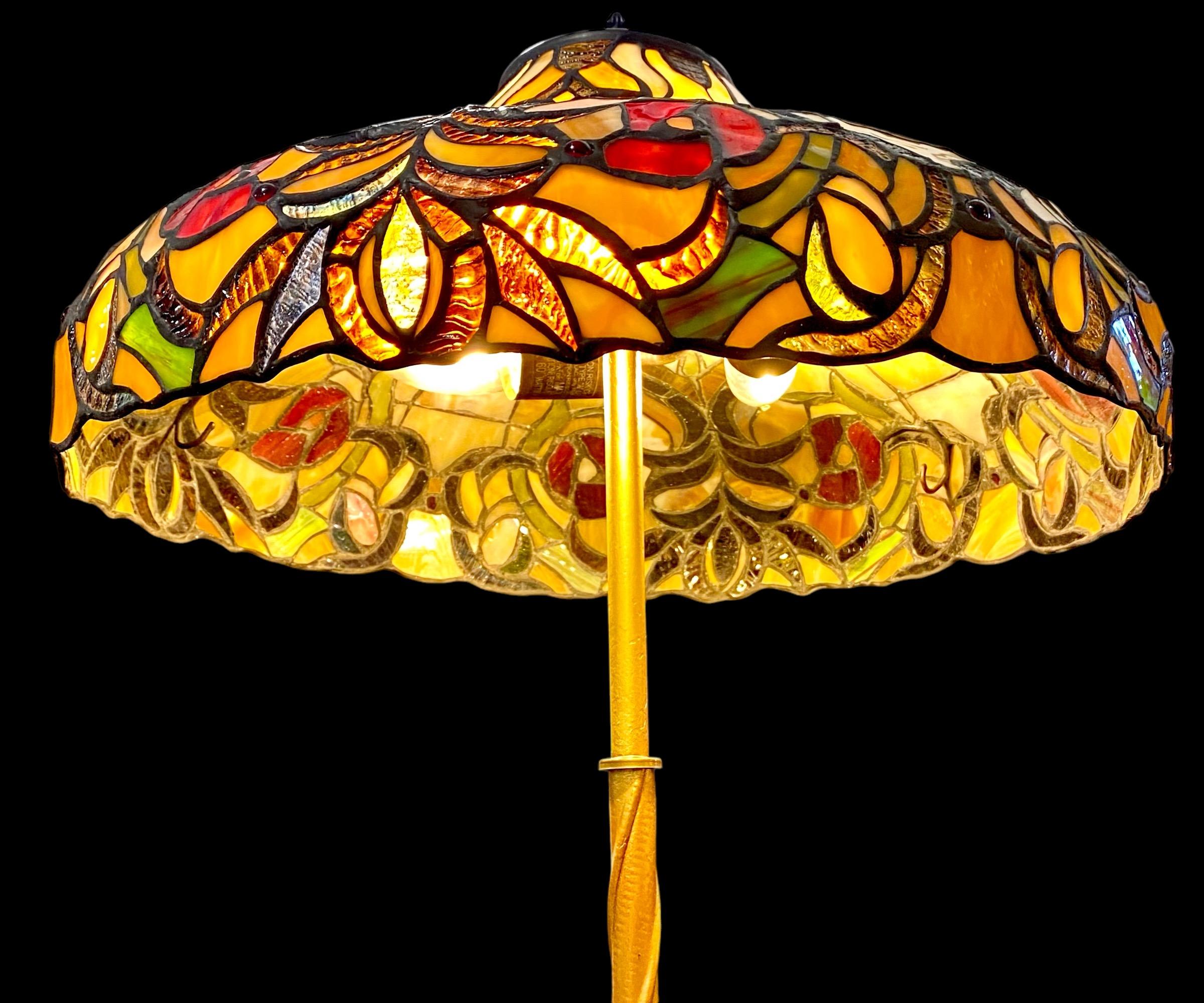An antique American Arts and Crafts brass plated floor lamp with a first quality Tiffany style stained glass pagoda shade.  A truly magnificent example of the Arts and Crafts period of American history. 