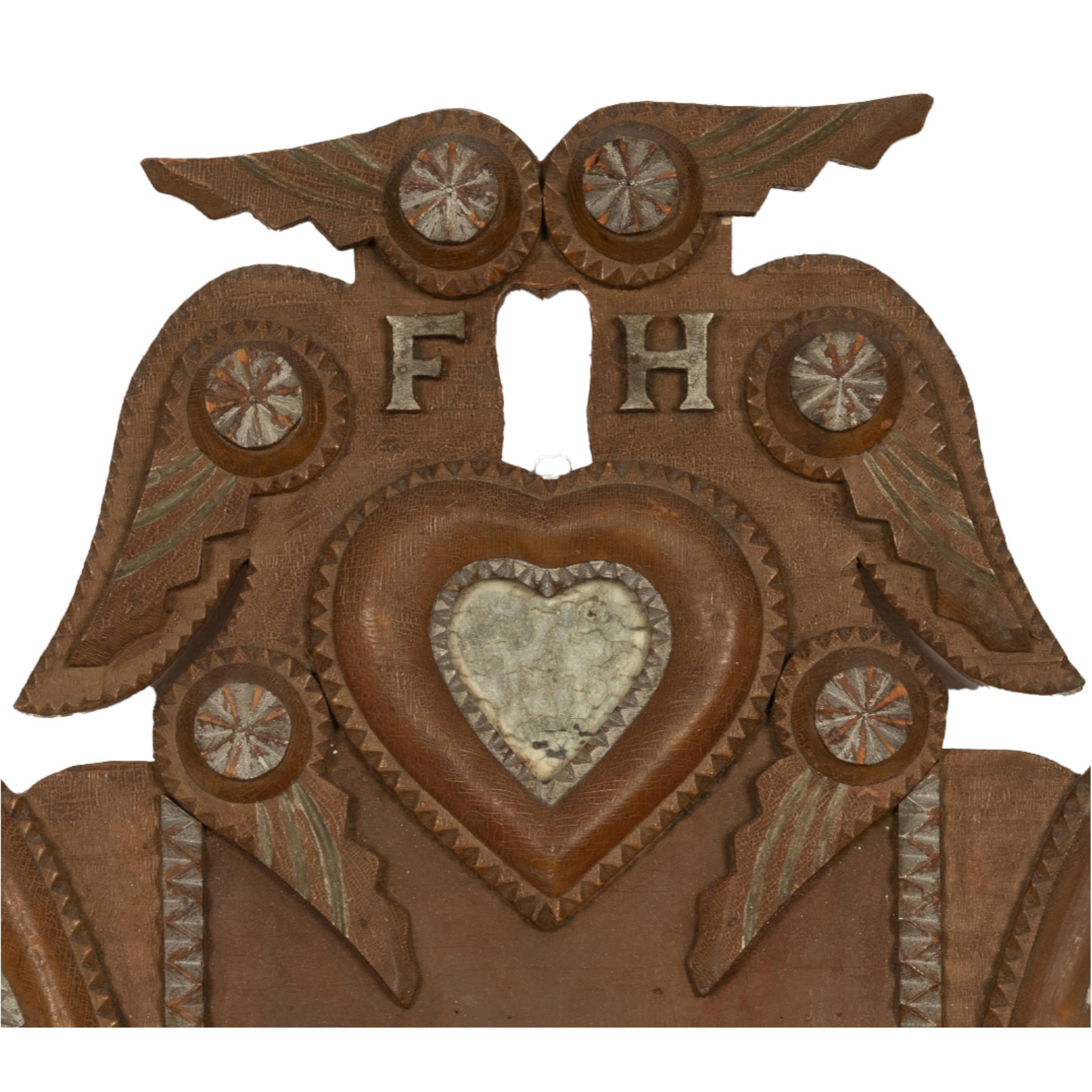 Un buen bolsillo de pared antiguo tallado Tramp Art con corazones, espejos y alas de John Zadora, Pensilvania, Circa 1910.
El bolsillo de pared es de gran tamaño y está decorado con 