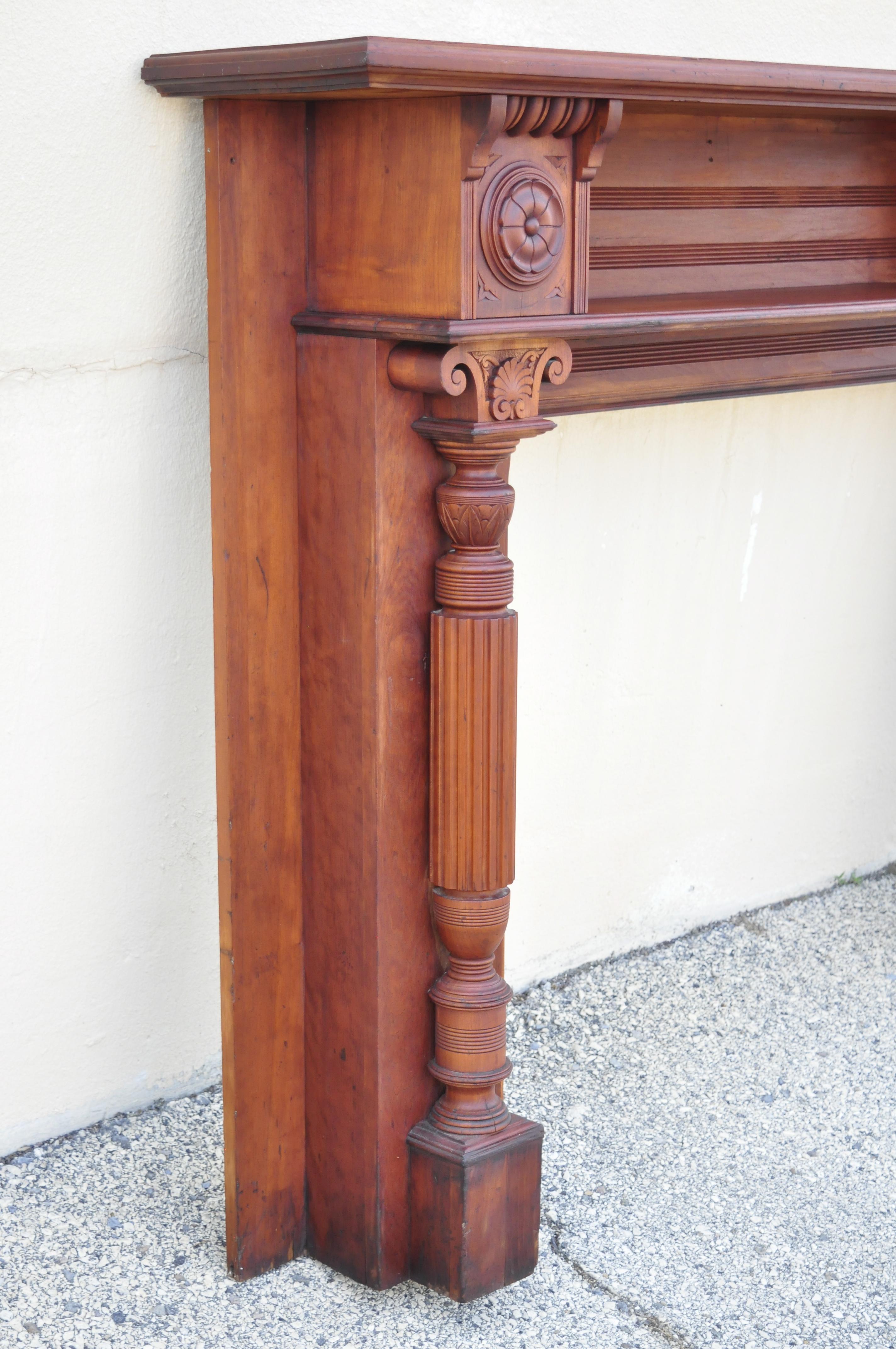 Antique American Victorian cherry wood carved column fireplace mantel shelf. Item features upper shelf, carved column supports, solid wood construction, beautiful wood grain, nicely carved details, original label, very nice antique item. Probably