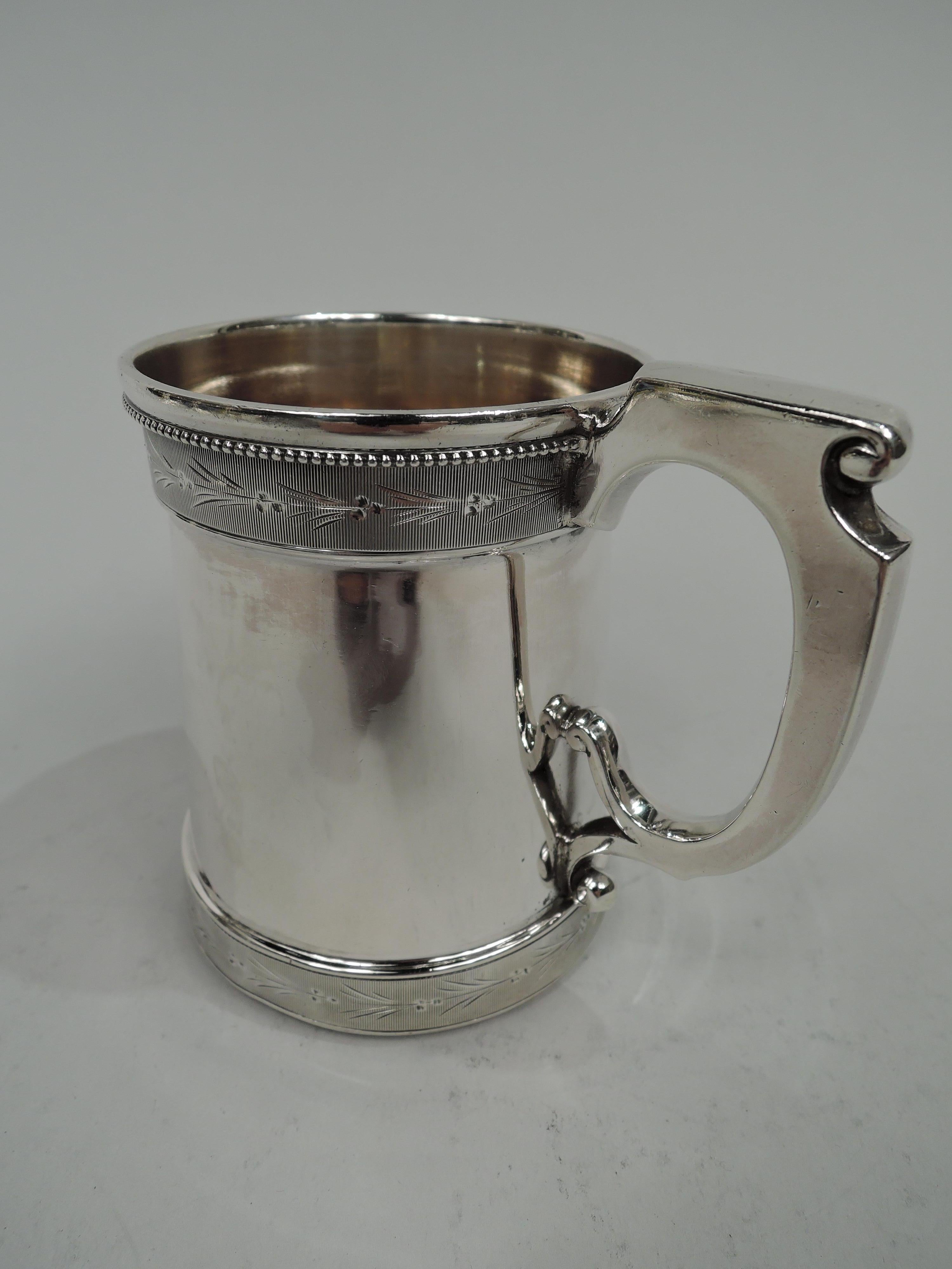 American Victorian Classical coin silver baby cup, circa 1860. Inset upward tapering sides between ribbed borders with engraved stylized leaf and berry ornament. Beading. Scroll bracket handle with volute scrolled thumb rest and split bottom mount.