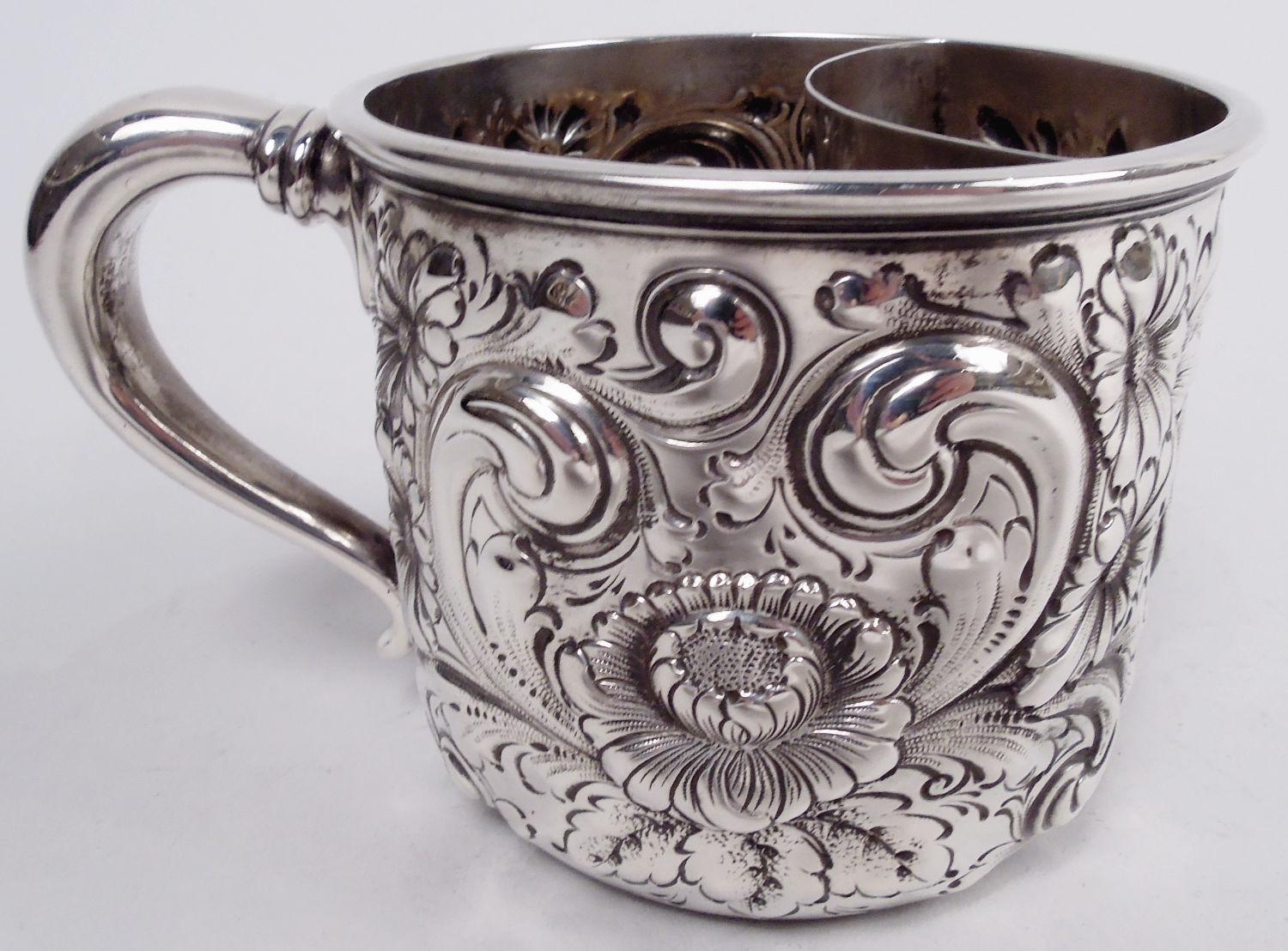 Taza de afeitar clásica victoriana de plata de ley. Fabricado por Howard & Co. en Nueva York en 1891. Forma de tambor con asa de voluta; interior montado con portaescobillas perforado. Volutas y flores de hojas repulidas. Completamente marcada,
