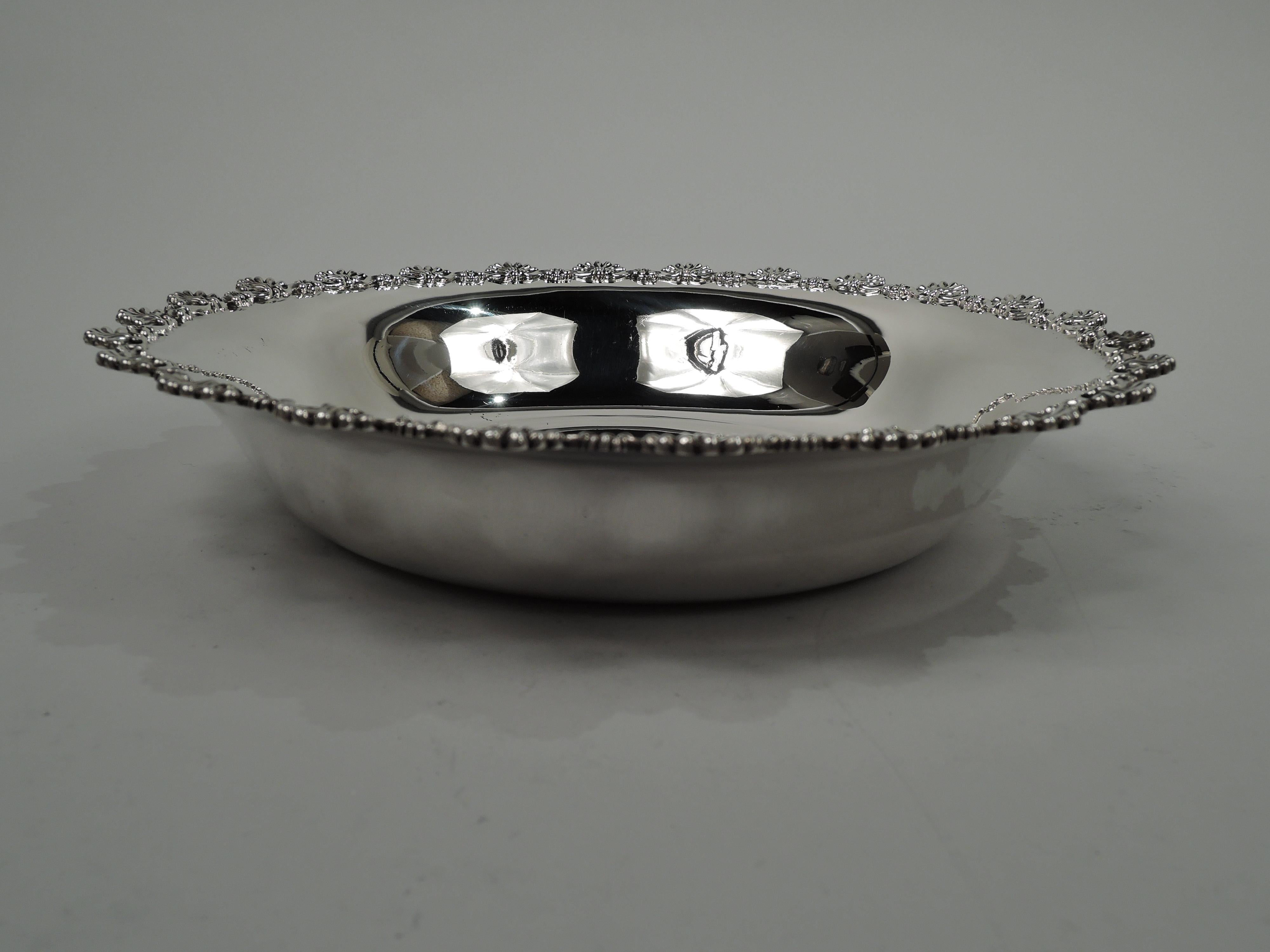 Victorian Classical sterling silver bowl. Made by Dominick & Haff in New York in 1895. Round with tapering sides. Applied and cast rim comprising alternating large and small scallop shows. Fully marked including dated maker’s and retailer’s (Rand &