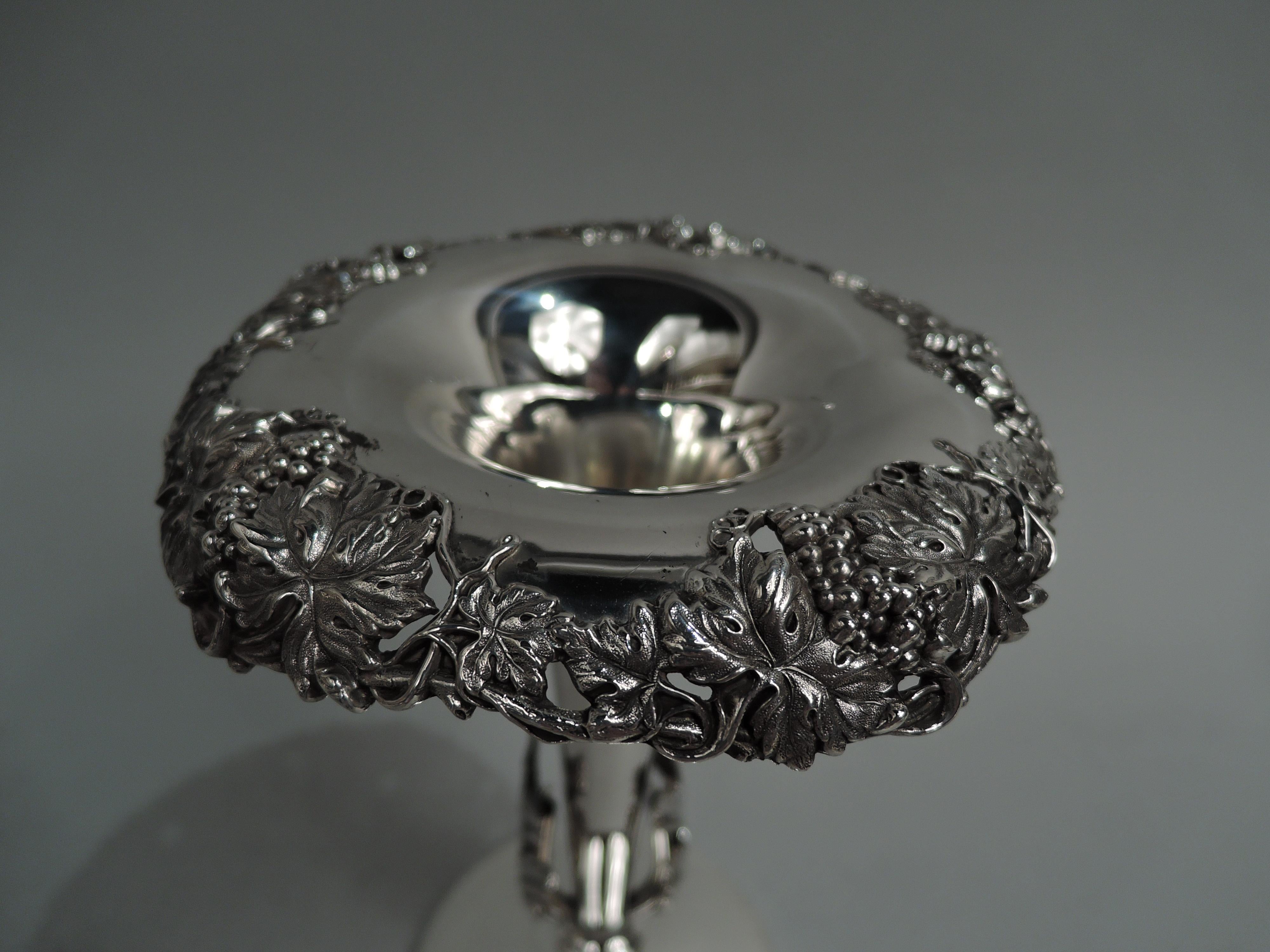 Victorian Classical sterling silver vase. Made by Mauser in New York, ca 1890. Narrow conical body between vertical acanthus leaves mounted to bottom; knop and raised round foot. Open irregular fruiting grapevine applied to turned-down mouth rim.