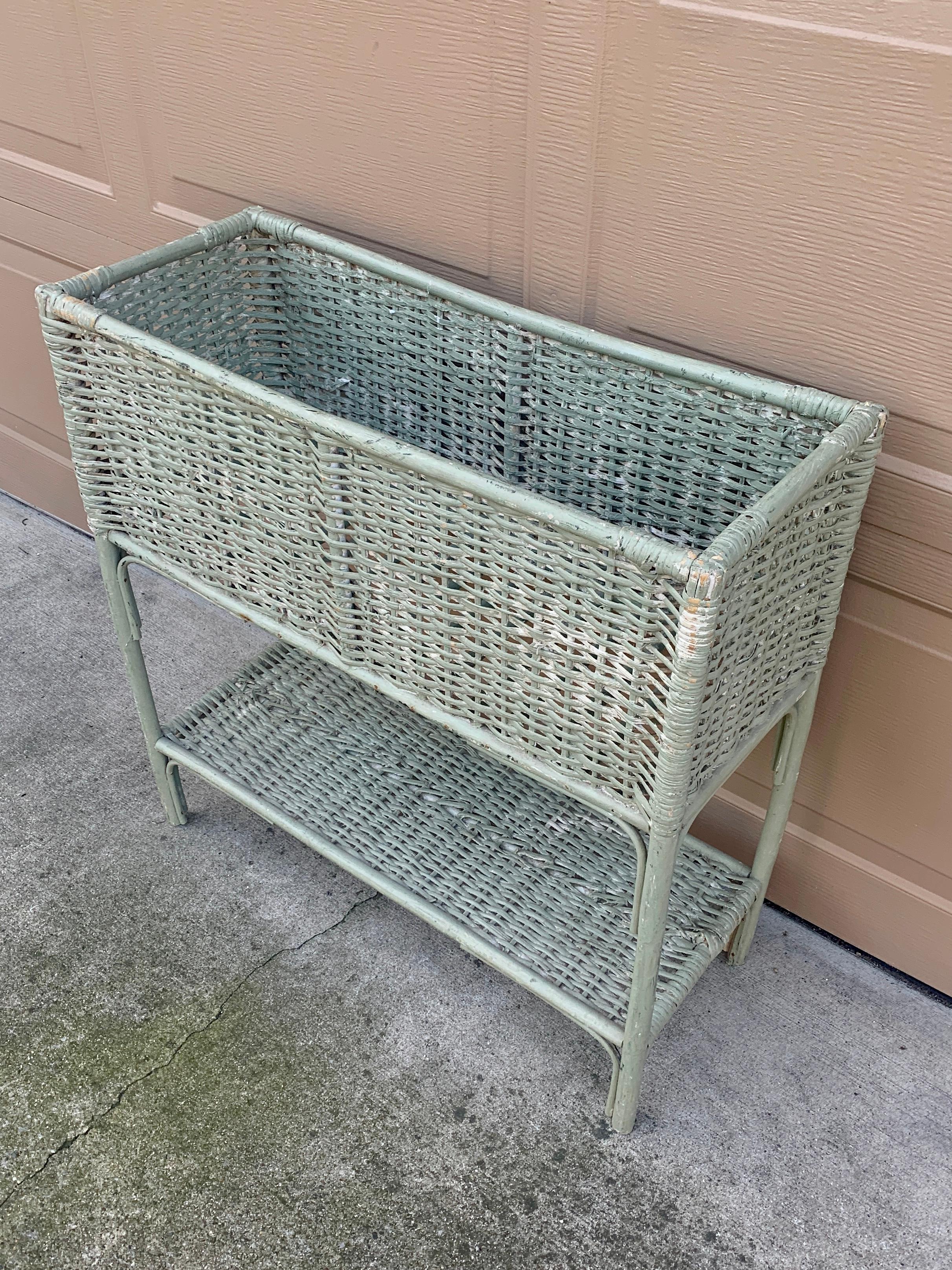 A gorgeous Victorian light green wicker plant stand with lower shelf. This piece would be charming indoors or on a porch, patio, or deck. 

USA, Late 19th Century

Measures: 29.25