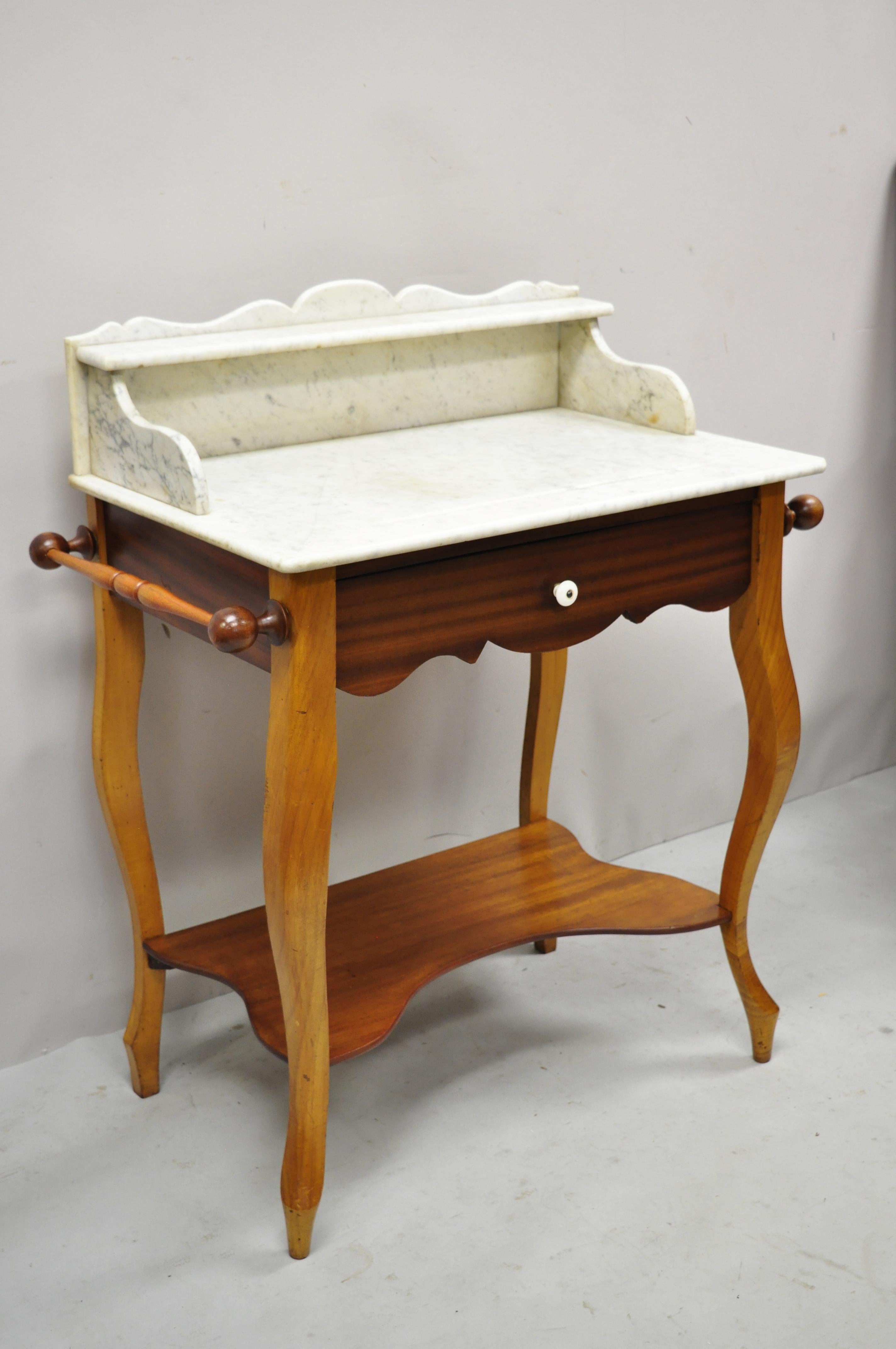 Antique American Victorian mahogany washstand commode marble top backsplash vanity. Item features marble top with backsplash, (2) towel bars/rods, beautiful wood grain, 1 dovetailed drawer, very nice antique item. 37