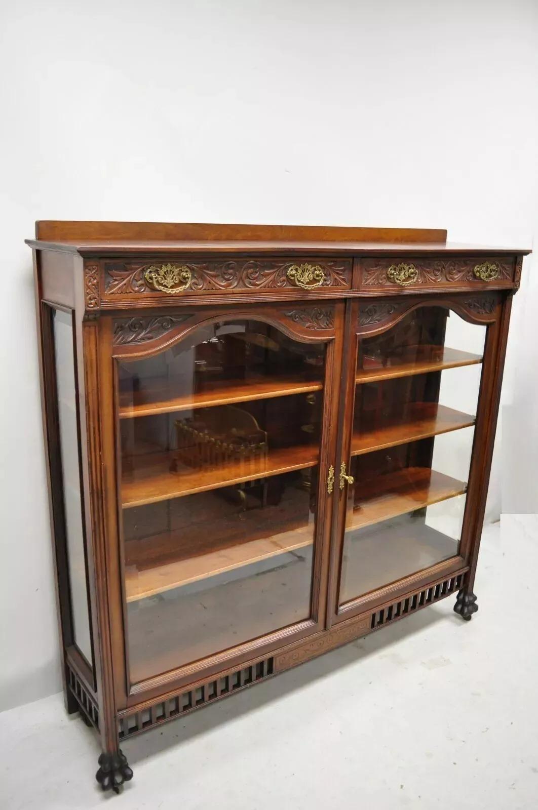 Antique American Victorian Paw Foot Carved Mahogany China Cabinet Bookcase Curio. Item features 2 beveled glass swing doors, 2 dovetailed drawers, 3 wooden shelves, carved paw feet, very nice antique item. Circa Late 19th Century. Measurements: 57