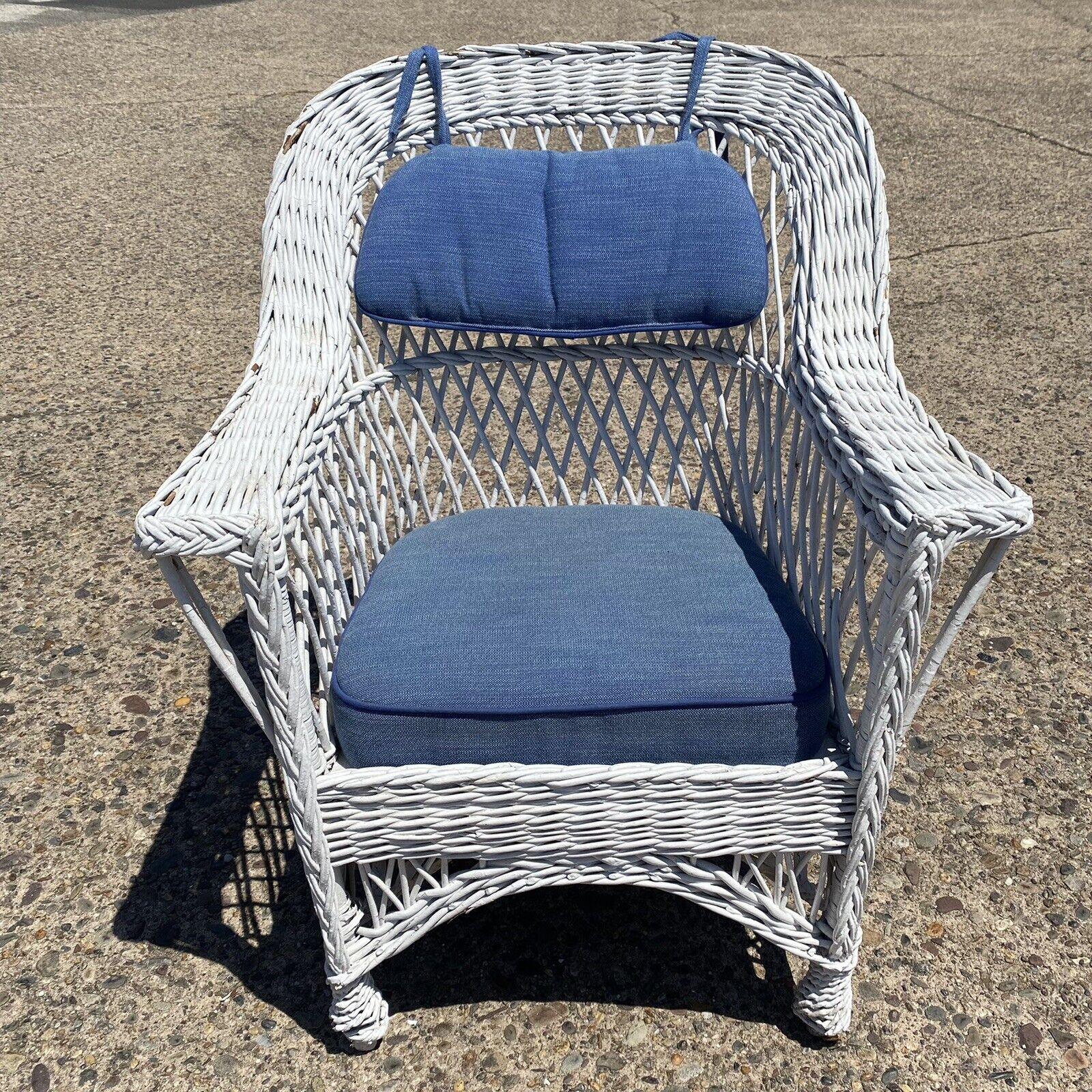 Antique American Victorian White Wicker Rattan Sunroom Lounge Arm Chair. Item features wicker wrapped wooden frame, blue cushions, very nice antique item, great style and form, very rare form. Circa early to mid 20th century. Measurements: 34.5