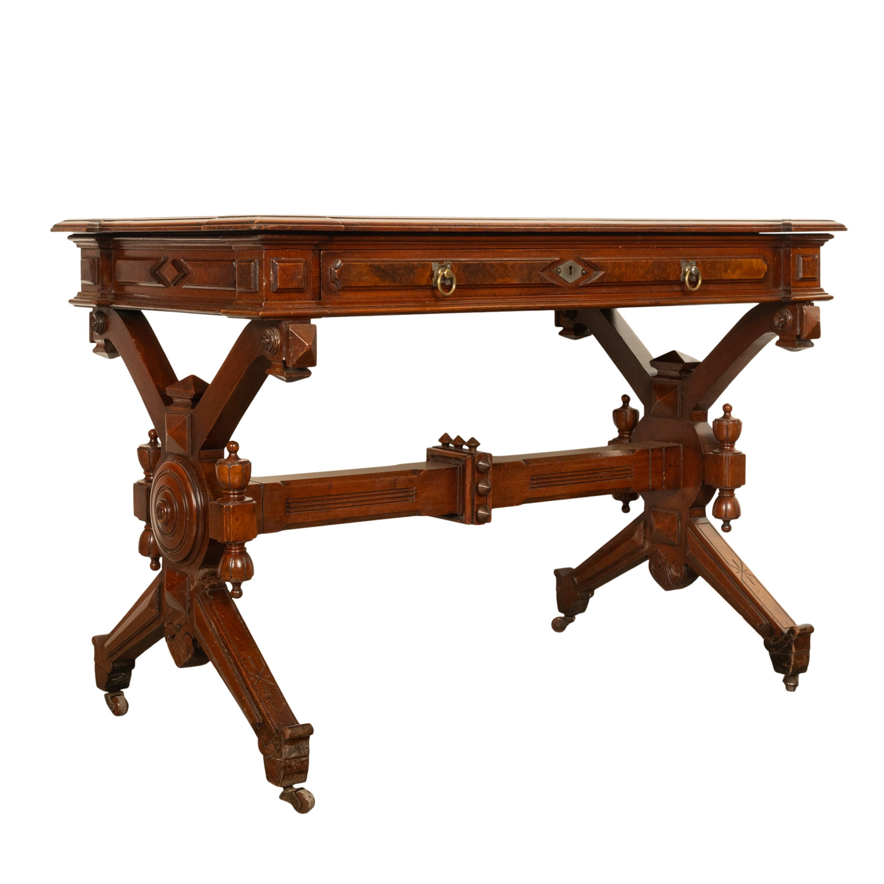 A good antique American walnut Renaissance Revival writing table desk, circa 1875.
The table demonstrating the influence of the Aesthetic Movement and designers such as Charles Eastlake. The table top having the original brown tooled inset leather