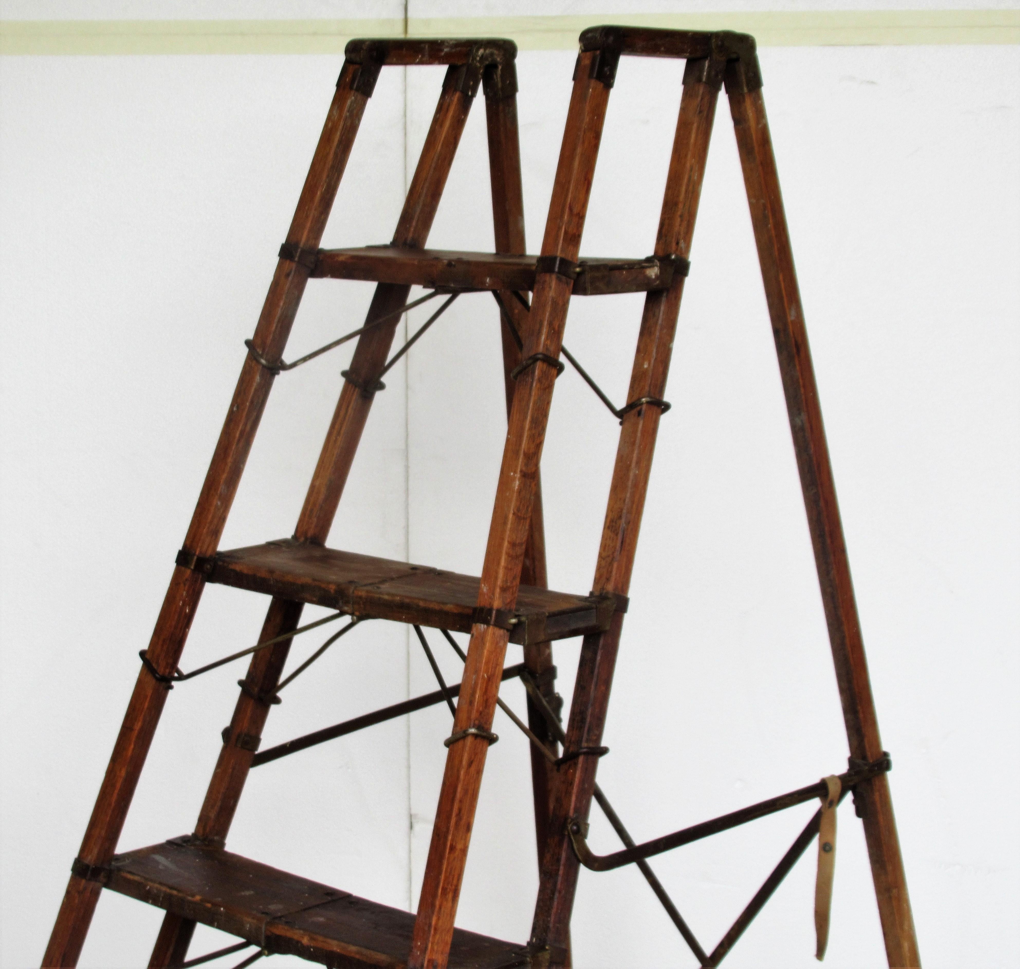 Antique American patent metamorphic ladder with oak framework, maple steps, iron hinges, rods, straps and rivets. Measures for use as shown set up in pictures - 49 inches high x 36 inches wide x 22 inches deep. The steps and sides collapse and fold