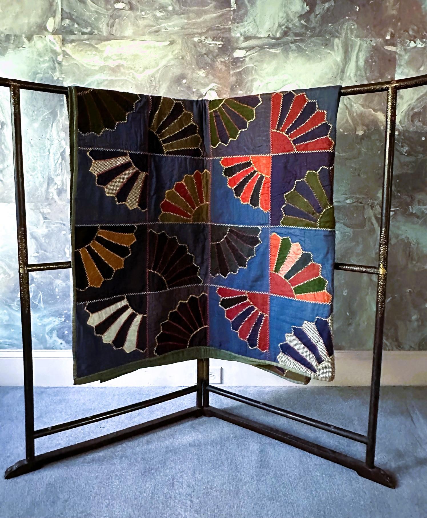 Ein antiker, handgefertigter Quilt aus Ohio (ca. 1890-1900). Der Quilt zeichnet sich durch ein auffälliges, quadratisches Muster mit Fächermotiven aus, das mit bunten Baumwollapplikationen auf einem Hintergrund in zwei Blautönen handgenäht wurde.