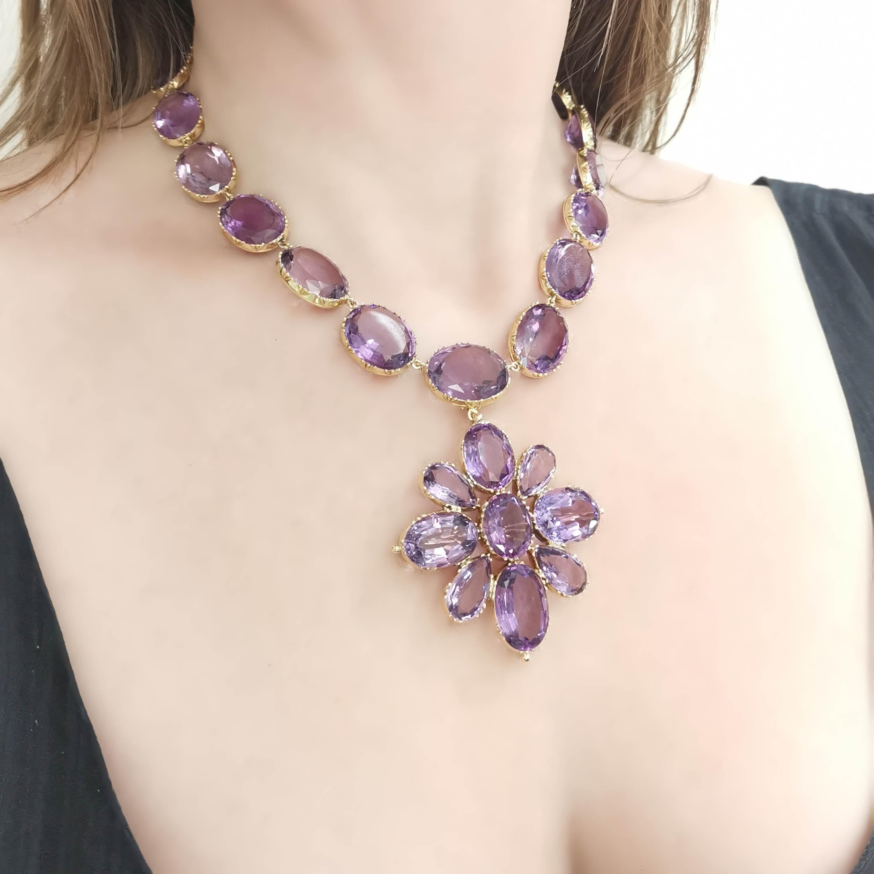 An antique amethyst and gold riviére necklace with large, oval faceted, graduated amethysts, in open backed cut down bezel settings, and an amethyst set box and tongue clast, with a removable cross pendant brooch, circa 1880. Estimated total weight