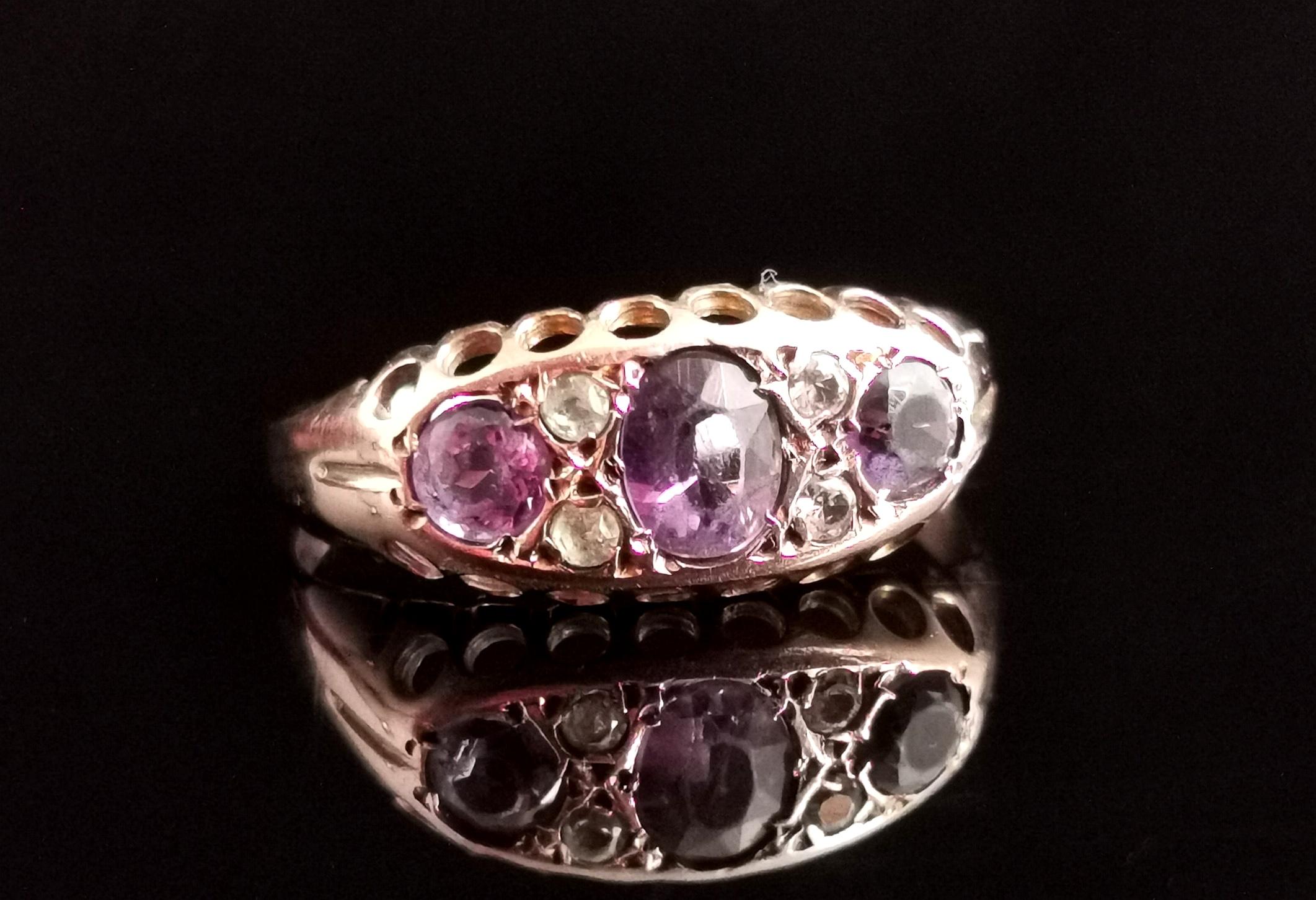 A pretty antique Amethyst and paste stone ring.

It is a boat head style ring in 9kt yellow gold.

It has three lovely mixed cut Amethyst stones with a light and rich purple tone intercepted by white paste stones.

It is marked on the inner face