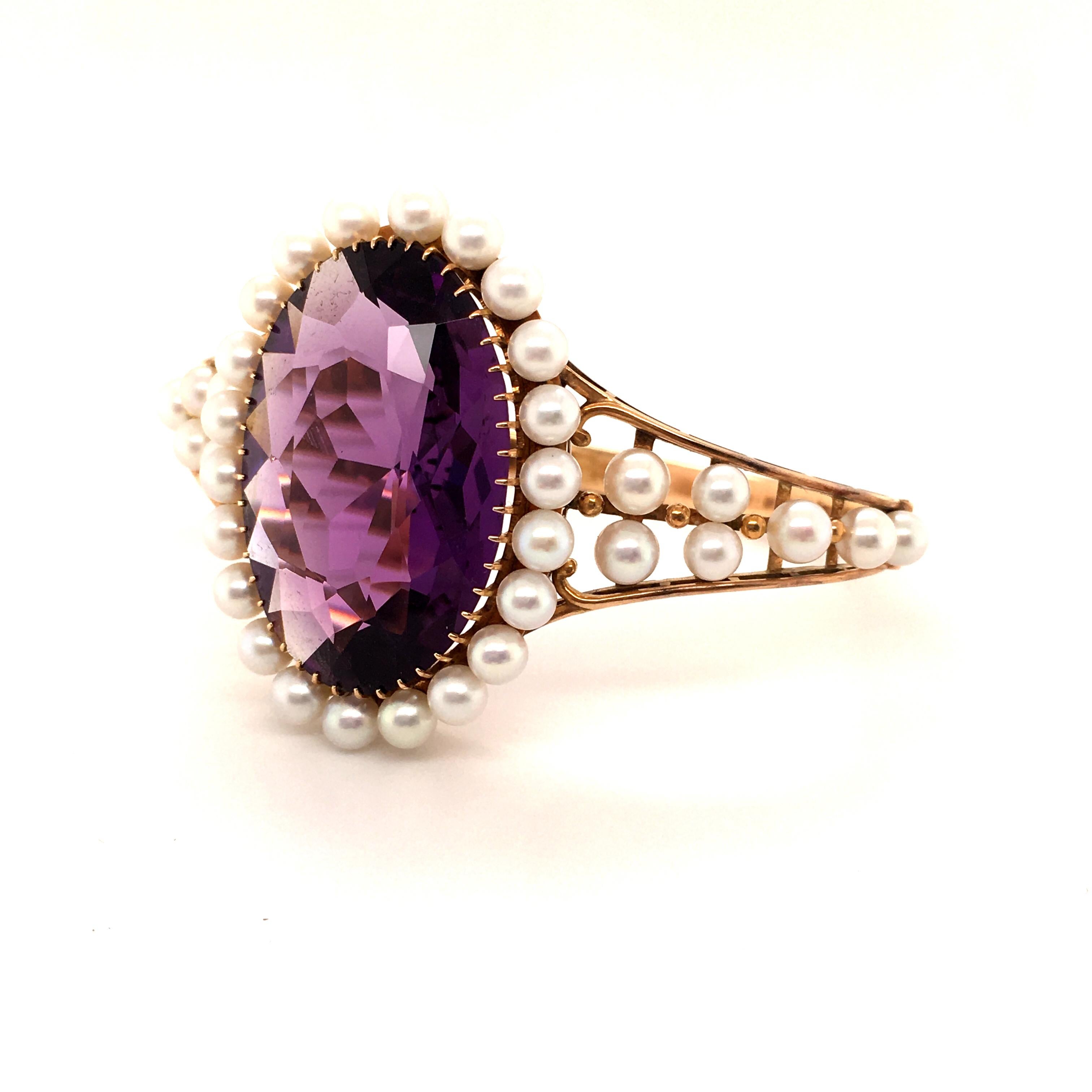 Center of attraction of this 1940s open work bangle is a 45 ct oval shaped, eye clean amethyst. The stone has a pleasant bluish-violet hue, not too oversaturated that allows the stone to show a lot of life. Ornamented with an entourage of Japanese