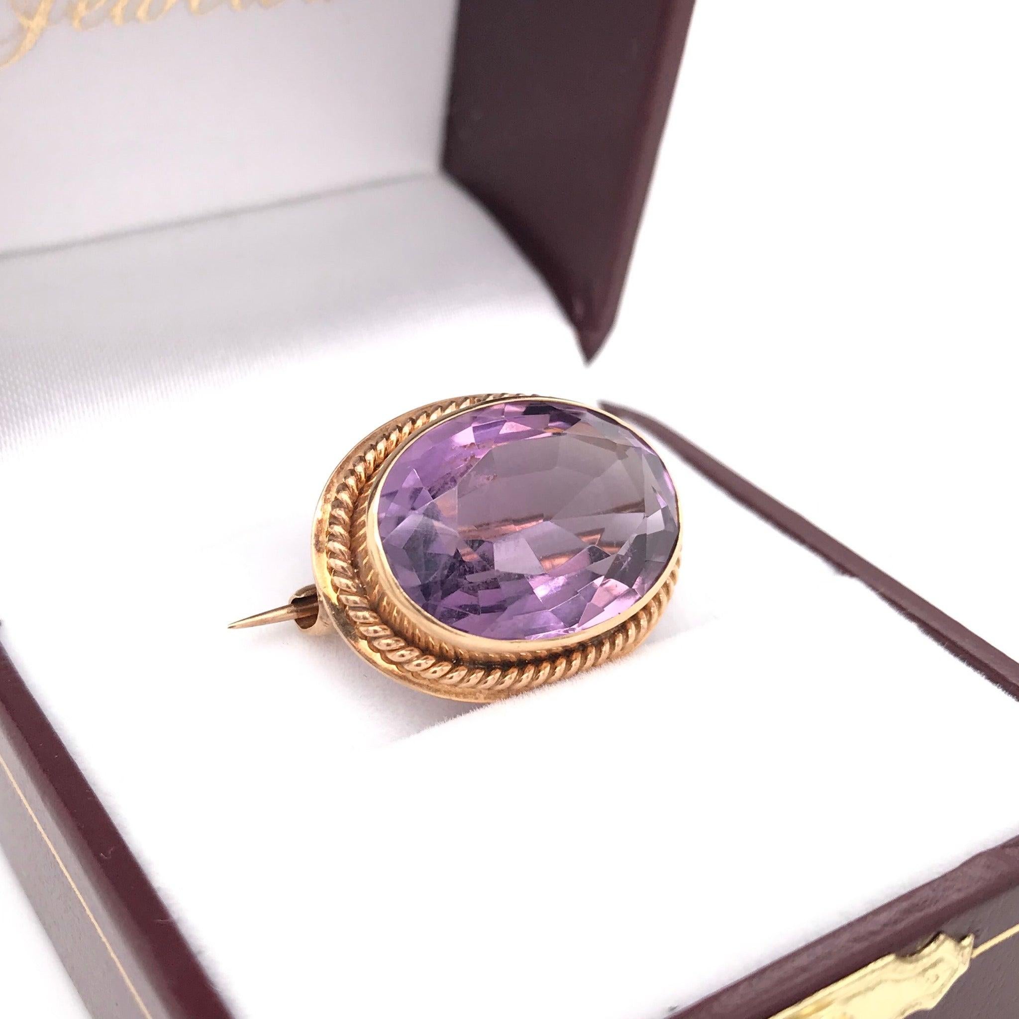 Questa antica spilla di ametista è stata realizzata a mano tra la fine del XIX e l'inizio del XX secolo. La montatura è in oro giallo 14k e la pietra centrale è una bellissima ametista viola tagliata su misura. La pietra è incastonata e la montatura