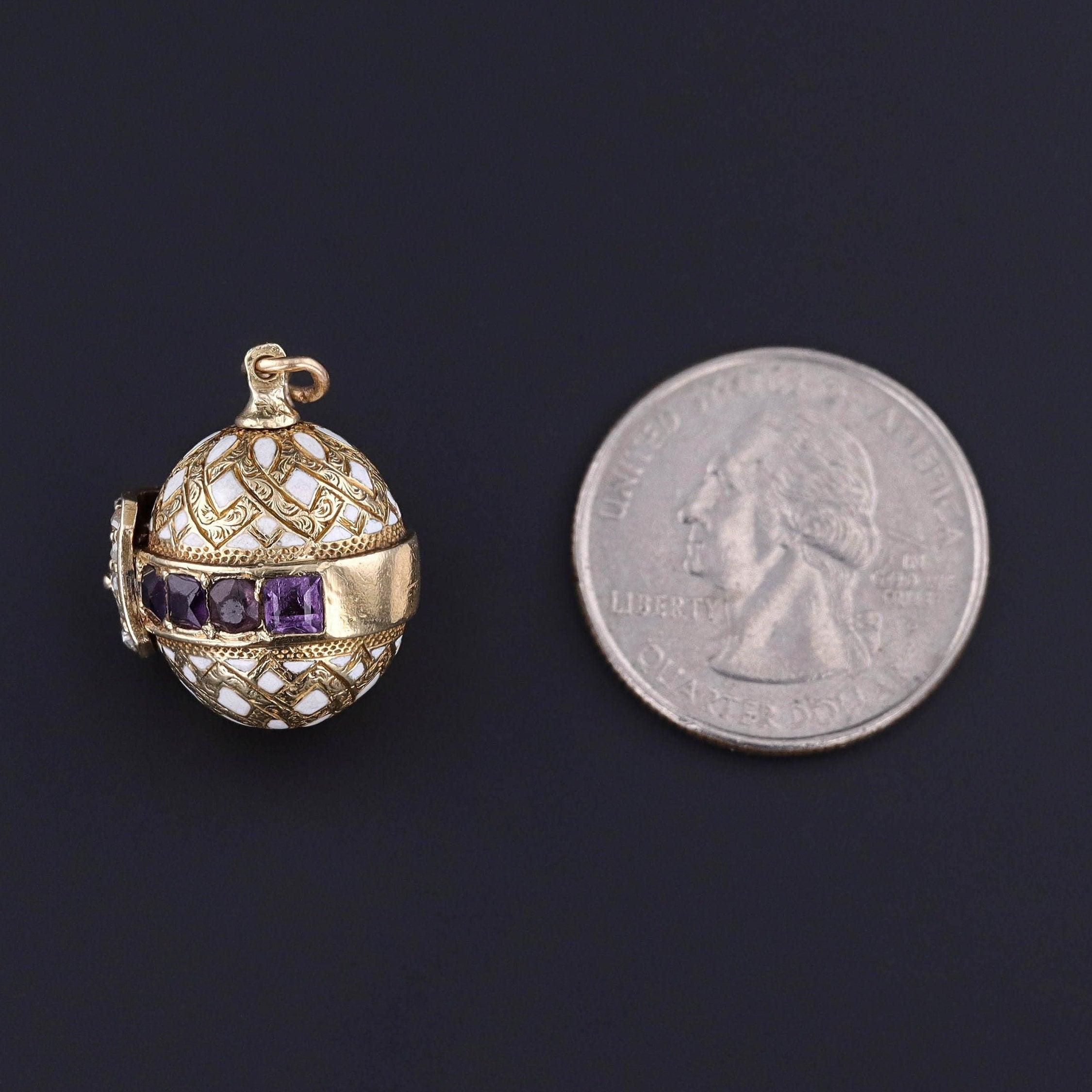 This antique pendant (circa 1910) features an 18k gold and enamel egg with a pearl, amethyst, and rose cut diamond buckle.

The piece measures 1 inch from the top of the jump ring to bottom by 0.65 inches wide. The charm is in good condition;