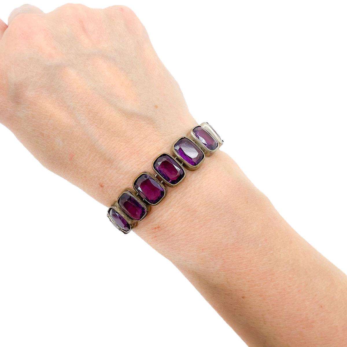 Un bellissimo bracciale antico in pasta d'ametista Rivière risalente al 1900 circa e forse anche prima. Grandi ametiste sfaccettate percorrono l'intero bracciale, creando uno spettacolo opulento di colori e storia. Divino.
Rivière si riferisce a un