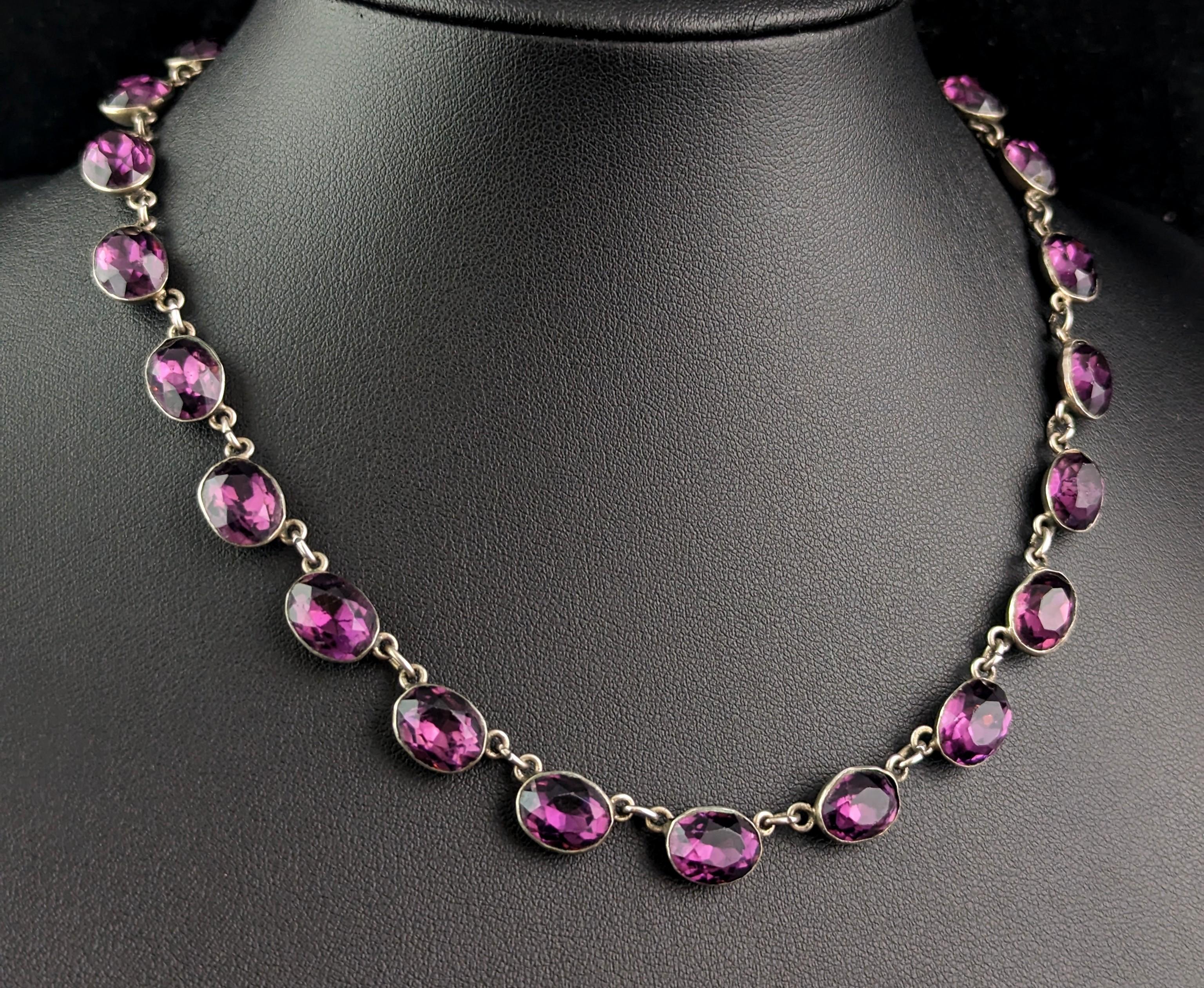 A tremendously good antique riviere necklace.

Early Victorian era this beautiful antique riviere necklace borrows much of its design elements from the Georgian era, it showcases wonderfully rich purple paste stones resembling amethyst, in closed