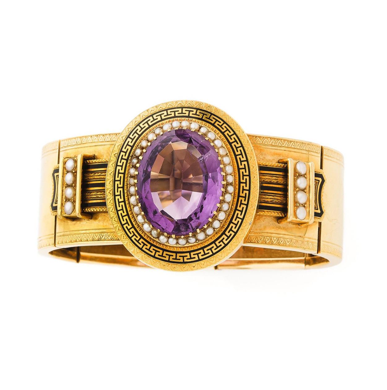 Bracelet decorated with an oval amethyst of approximately 22 carats in a surround of white natural pearls in a black enamel frieze decoration. Setting with 18K yellow gold engraved decoration. Safety chain.
Wrist circumference: approximately 18.5