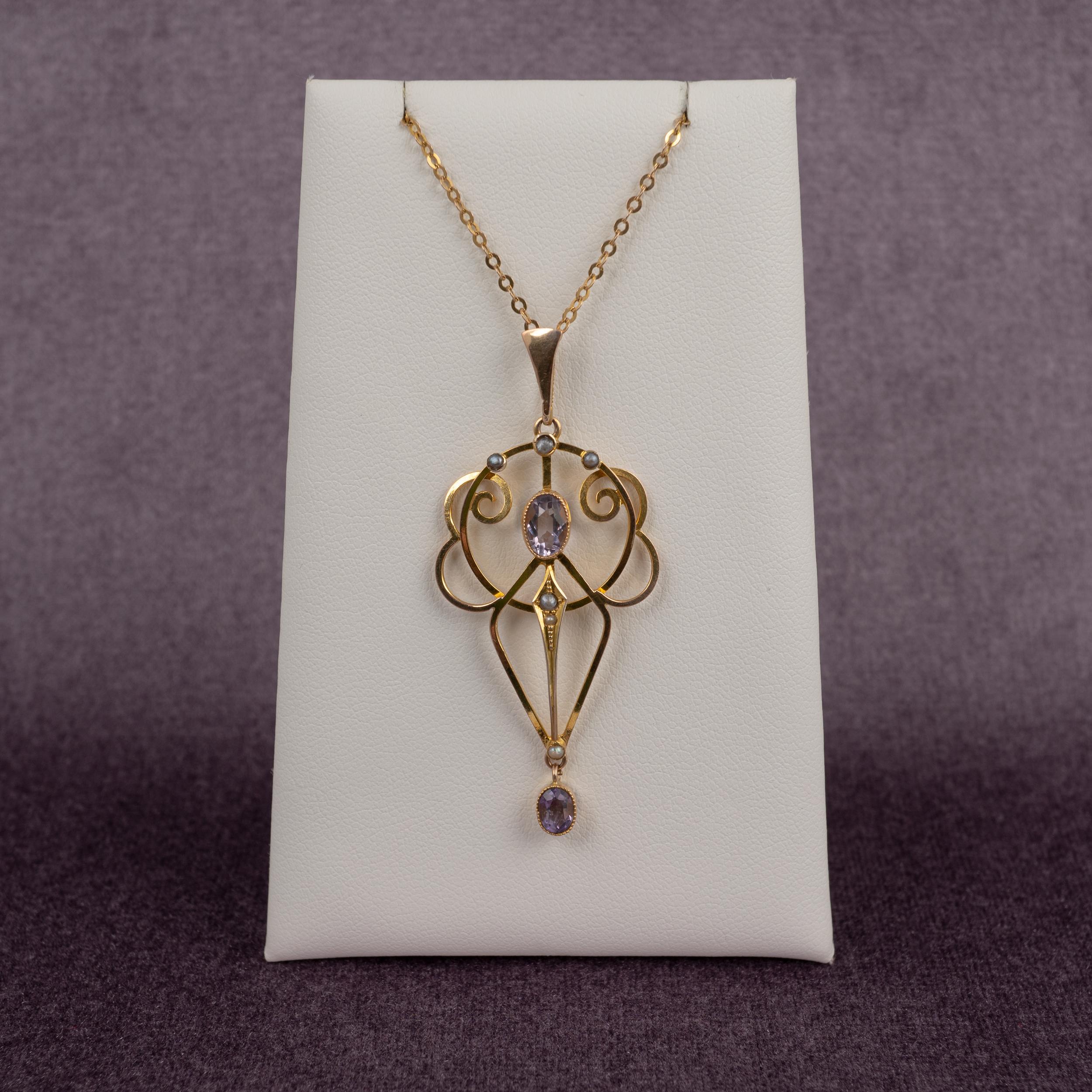 This exquisite yellow gold amethyst and pearl pendant necklace dates back to the early 20th century.

The delicate gold frame features a center oval cut amethyst and a further oval cut amethyst drop. A total of 6 seed pearls are set geometrically