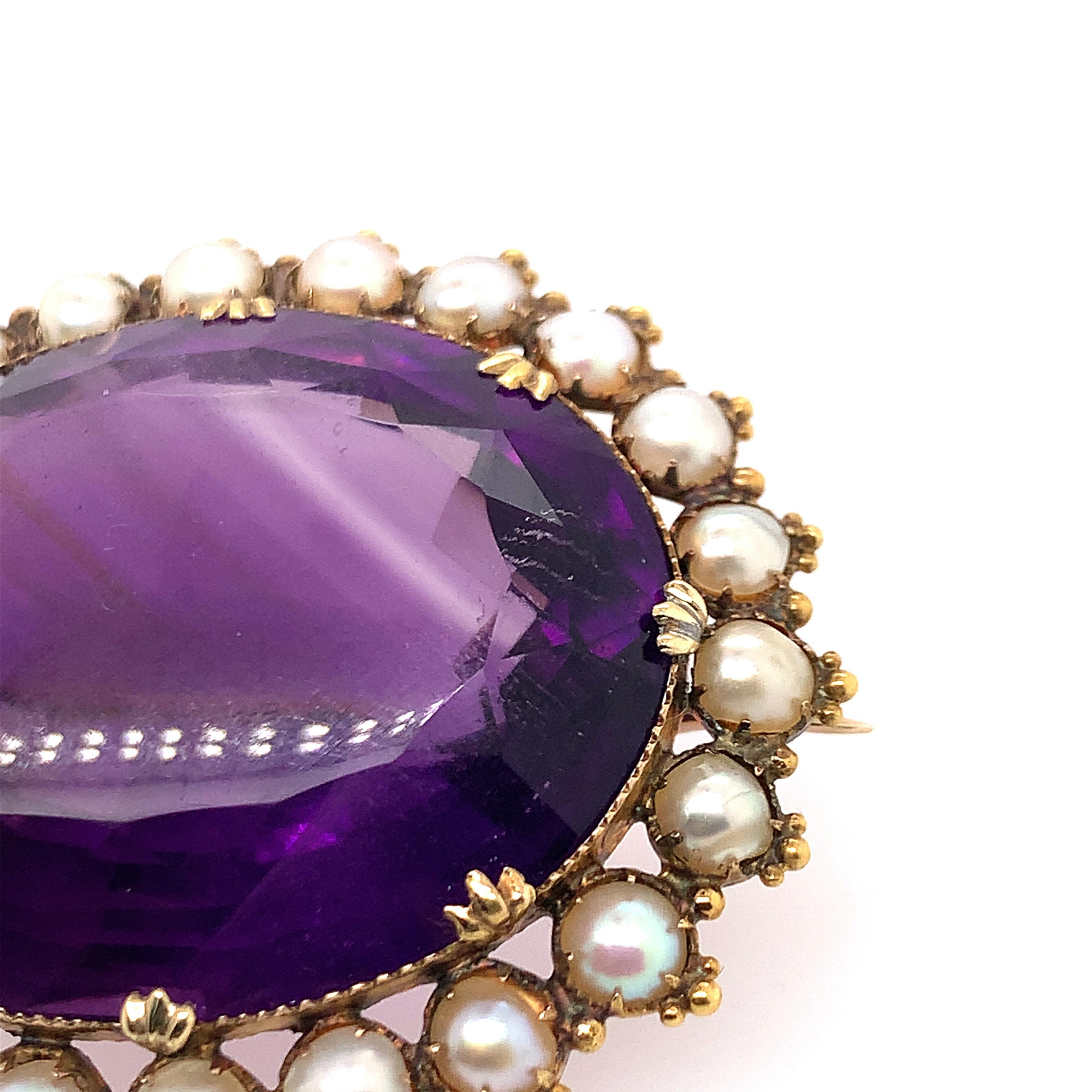 Centering a large oval amethyst weighing approximately 66.00 carats, the scalloped frame accented with split-pearls, in 18k gold
Weight: 20.2 grams
Brooch measuring 45 x 37 mm

Amethyst of a medium tone of strong purple colour, good clarity, good