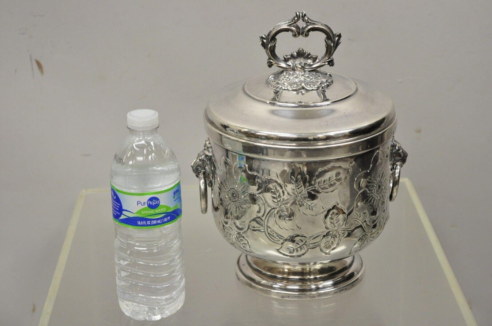 Antique Amston Regency Style silver plated lion head ice bucket. Item features mercury glass lined, lid with ornate handle, lion heads and drop rings to sides, floral debossed engravings to bucket, original stamp, very nice antique item. Circa Early