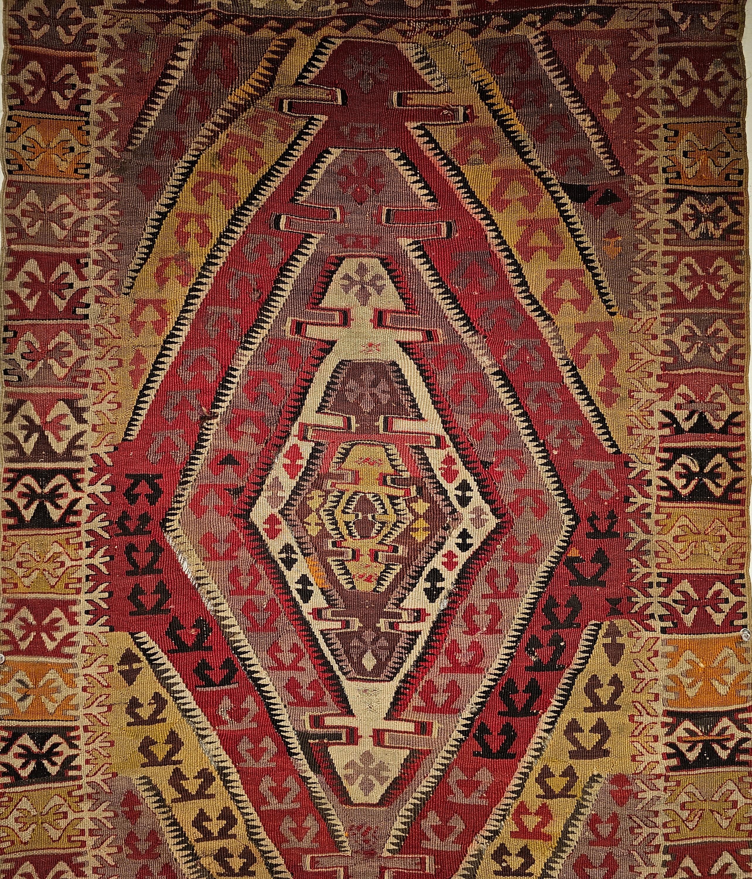  The beautiful Anatolian Kilim area rug with a very unique geometric pattern of radiating medallion from the center each with a different background color including ivory, pink, red, yellow and brown.  The earth tone colors produced by the use of