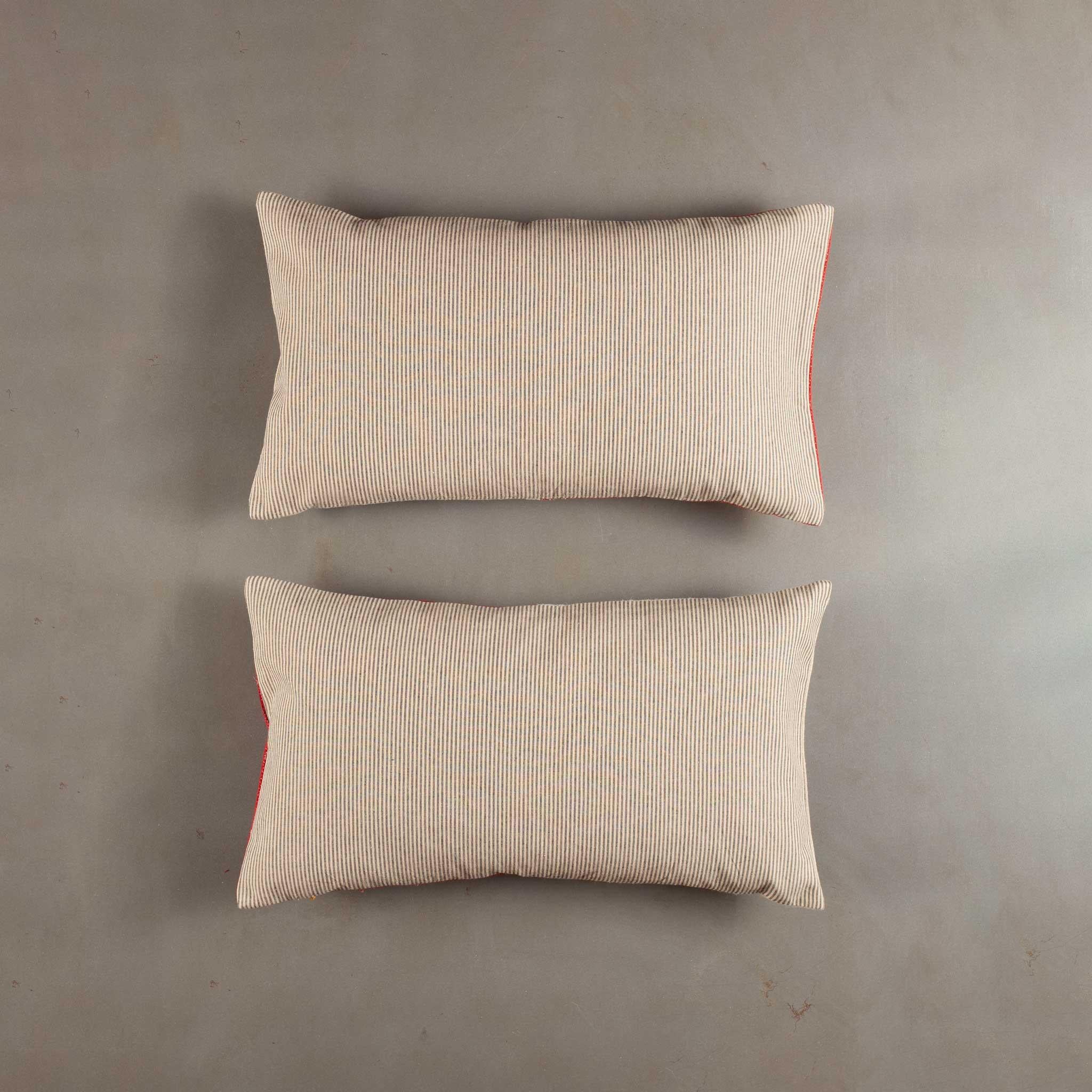 Realizzate con un mix di tessuti antichi e contemporanei, queste fodere per cuscini mostrano un sorprendente gioco di tradizione e semplicità moderna. Il pannello di cotone rosso tessuto a mano, risalente al XX secolo e proveniente probabilmente