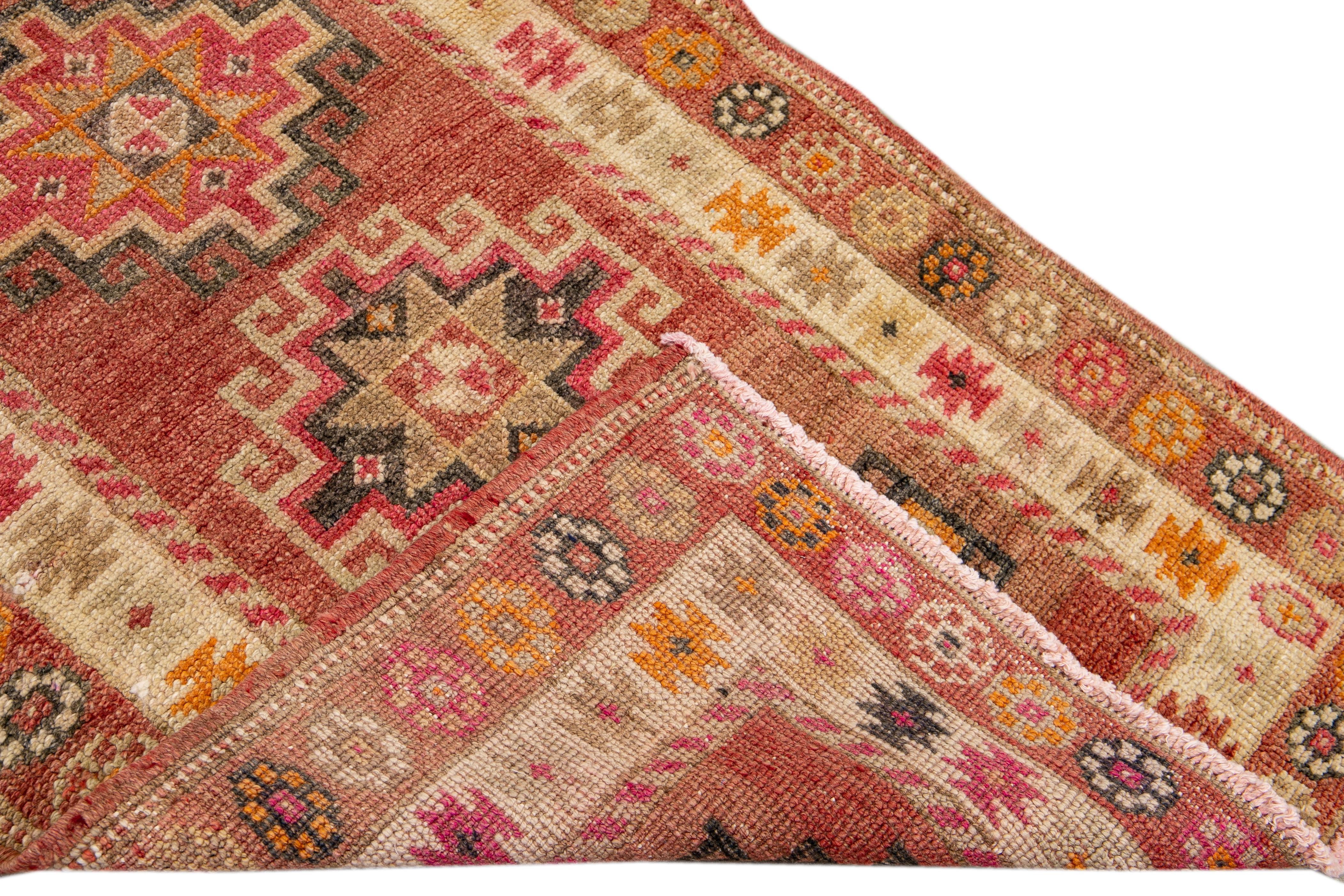 Beautiful Anatolian village runner hand-knotted wool with the light rusted coral field, ivory, pink and gray accents in geometric multi medallion design.

 This rug measures 2' 11
