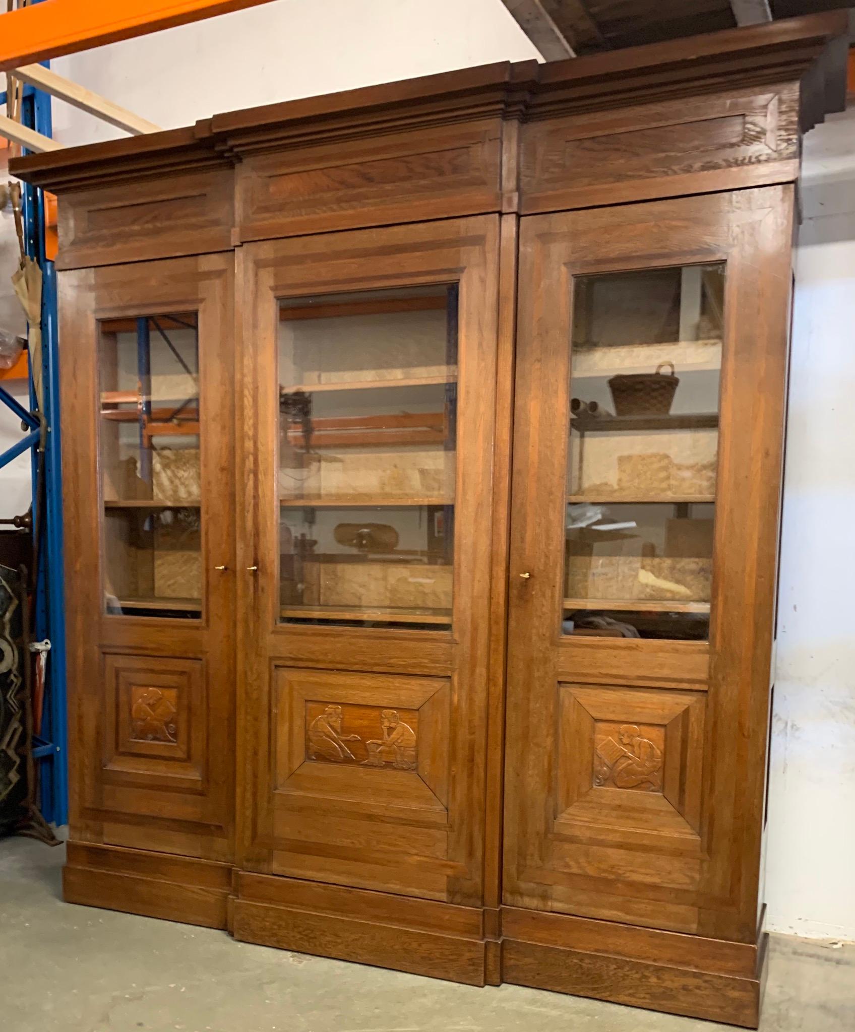 Unique three-door Arts & Crafts bookcase / book shelves with hand carved sculptural door panels. 

If you are looking for a truly stylish and top quality crafted bookcase, then this fully dismountable, solid oak specimen with inlaid details and