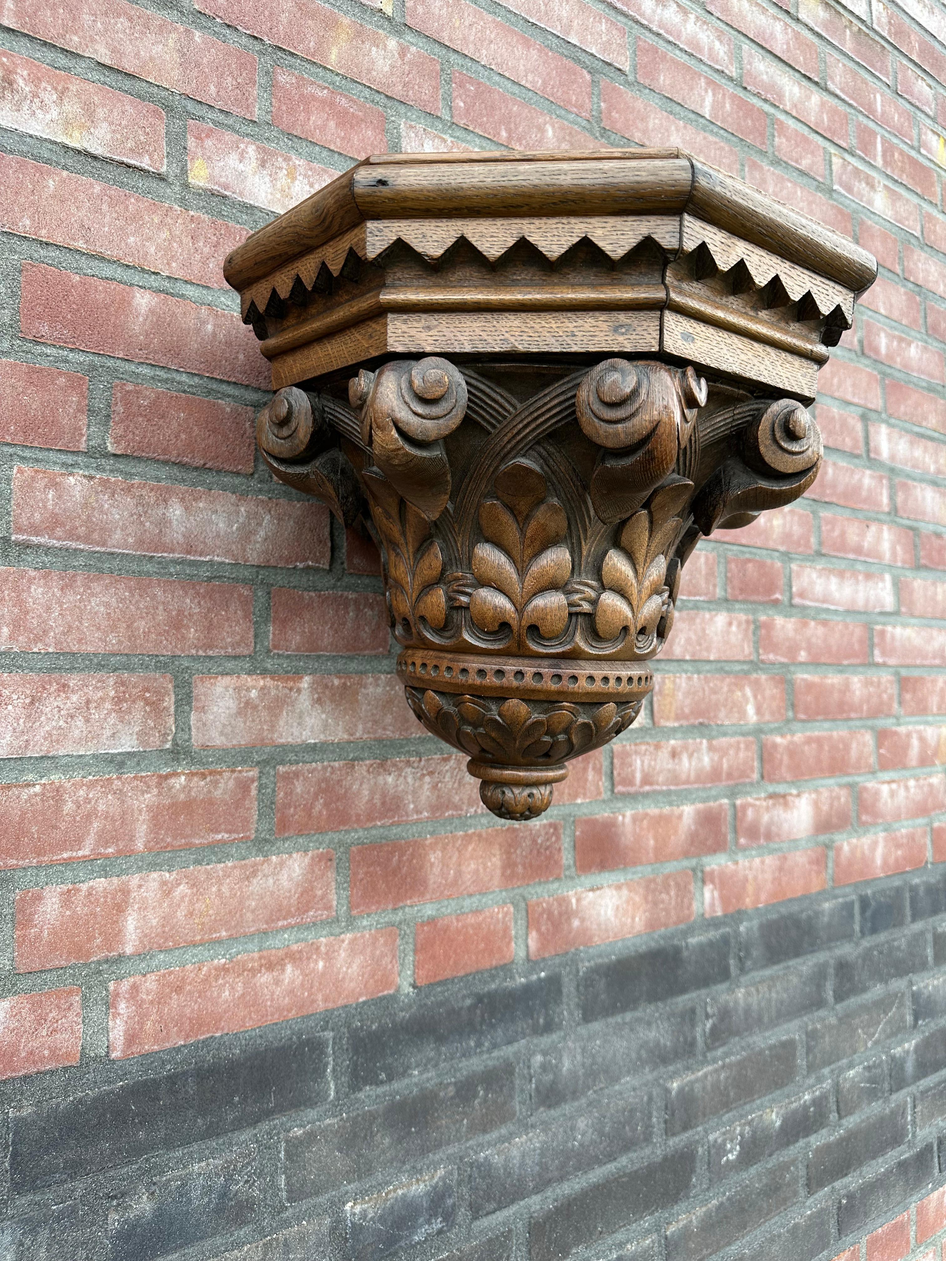 Great looking and deeply carved Gothic Revival bracket for displaying a Saint statue.

This Gothic console for wall mounting dates from the late 1800s and it has a marvelous combination of floral Gothic elements that make it a joy to own, to use and