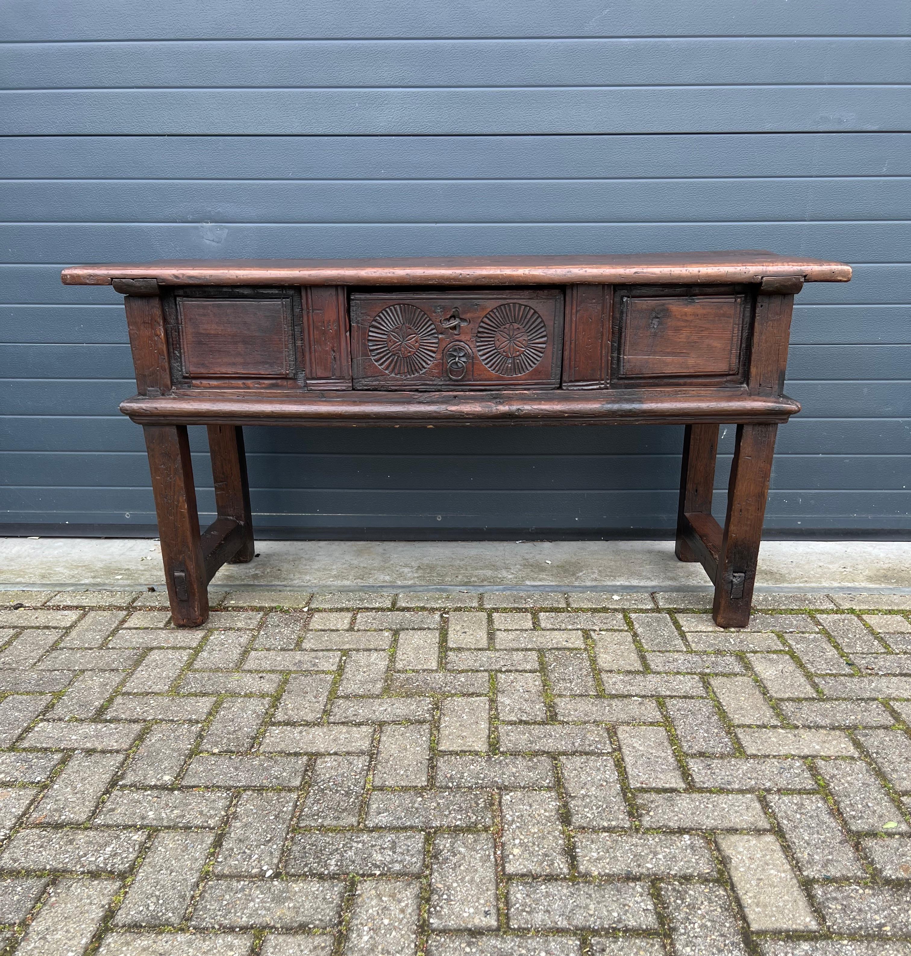 Beautifully time worn, mid to early 18th century side table with drawer.

If you are looking for a truly ancient looking and crudely stylish side table to decorate your living room or entry hall then this rare antique specimen could be flying your