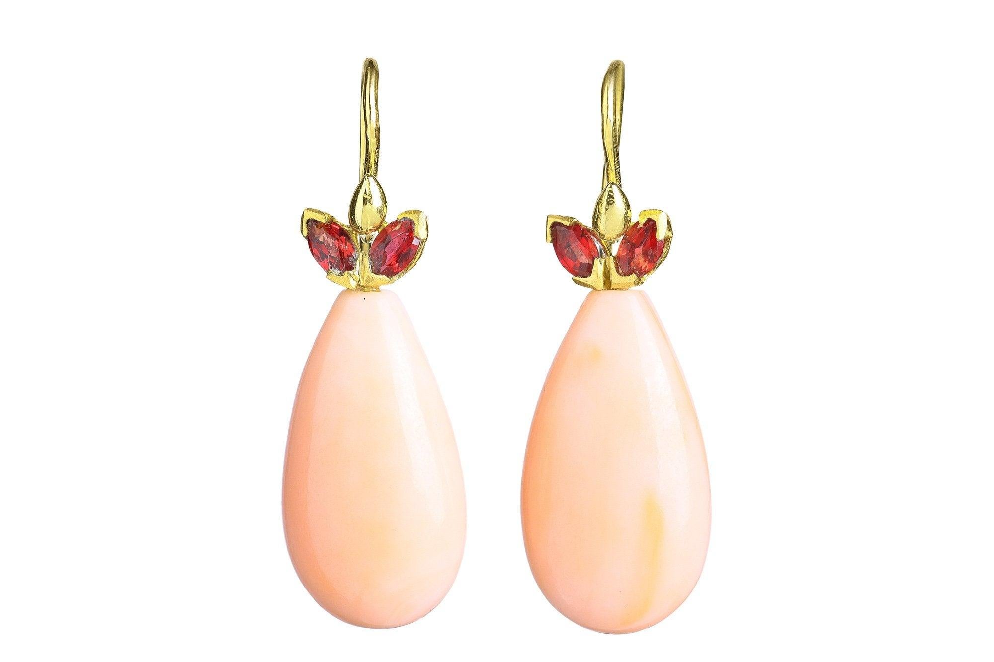 Crimson sapphire wings elevate these pure pale angel pink antique coral teardrop earrings. Wear everyday or on the most special of occasions.

GS636CrlRSapp 22x12.5mm smooth antique pink coral teardrop topped with crimson marquis sapphire 18k wings