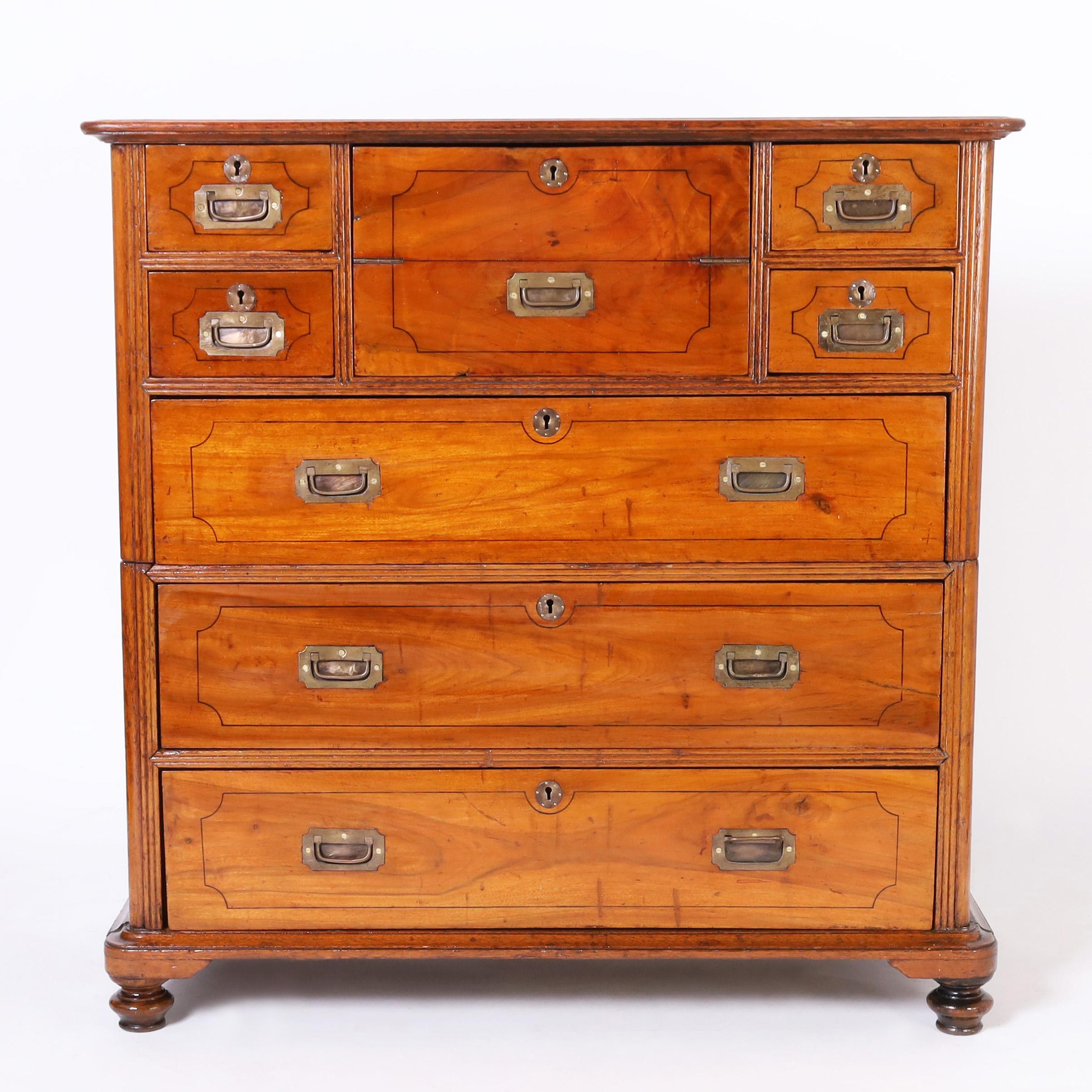 Rare and remarkable Anglo Chinese chest handcrafted in teak with seven drawers and a foldout desk, campaign brass hardware, and turned feet. French polished in the traditional old world manner.