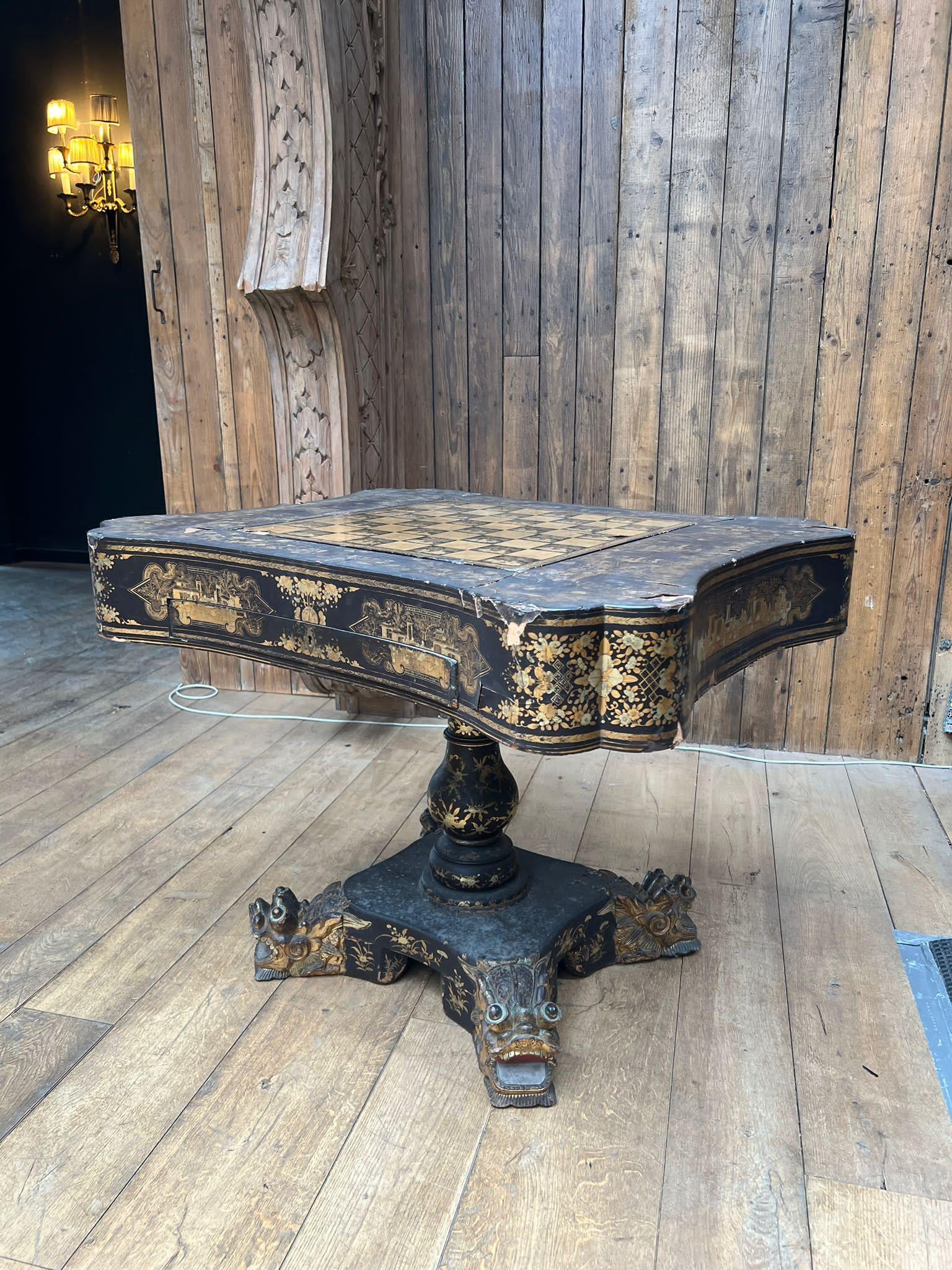 Rare table de jeu décorative de style anglo-chinois datant du milieu du 19e siècle, en laque noire avec des motifs chinoiseries complexes peints à l'or. Le plateau en forme est centré sur un superbe échiquier peint à la main, orné d'une alternance