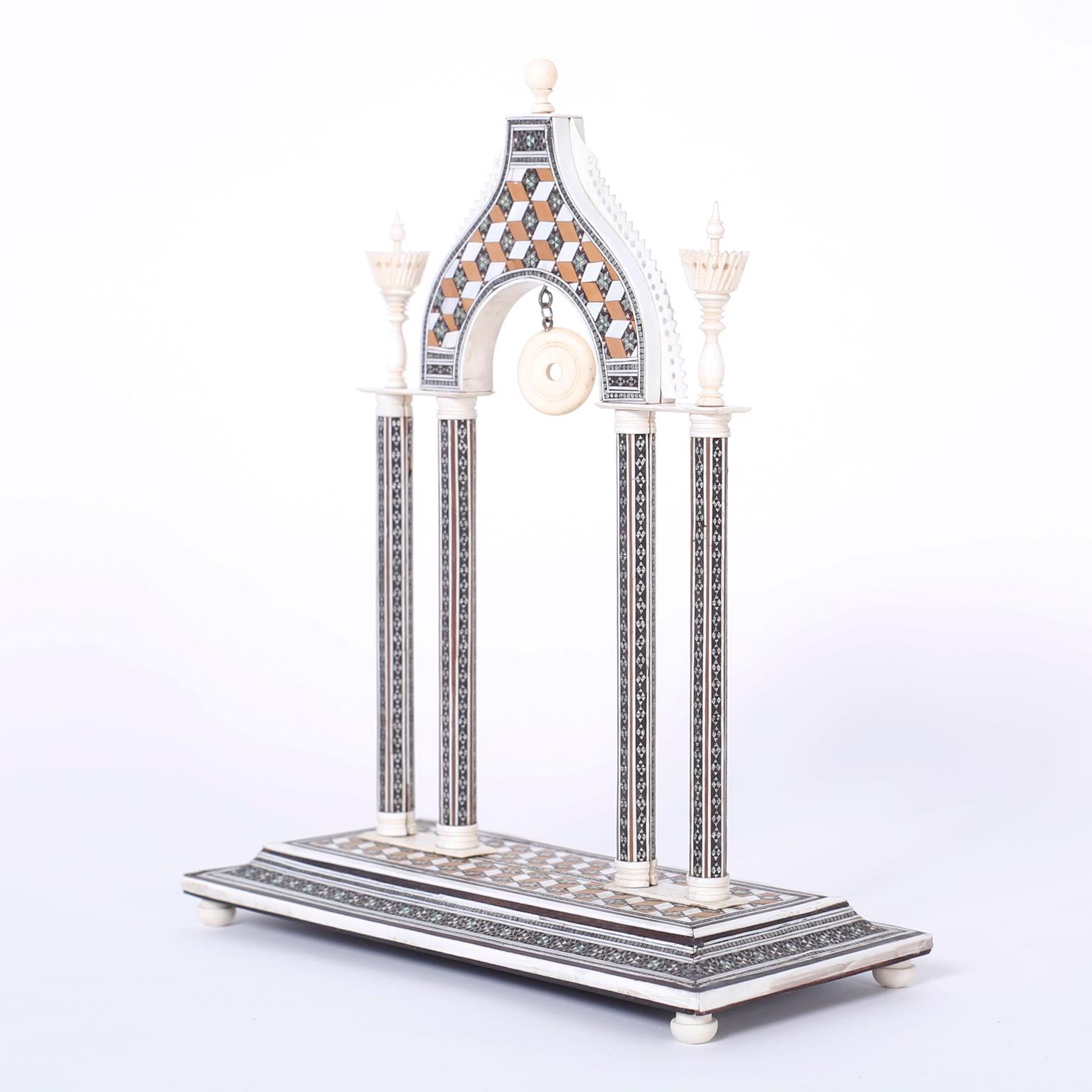 Architectural Anglo Indian model of an arch crafted in carved bone. The model is complete with finials, columns and a footed plinth inlaid with exotic hardwoods and mother of pearl in a micro mosaic technique.