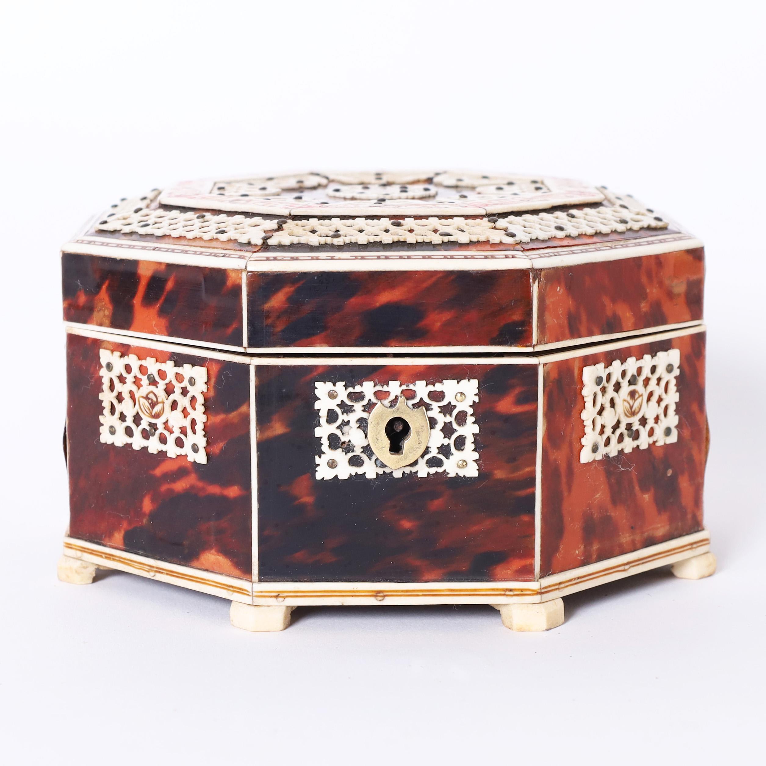 Impressive antique Anglo Indian box crafted in mahogany, clad in tortoise shell, and ambitiously decorated with bone. The inside has a mirror and red felt lining. 