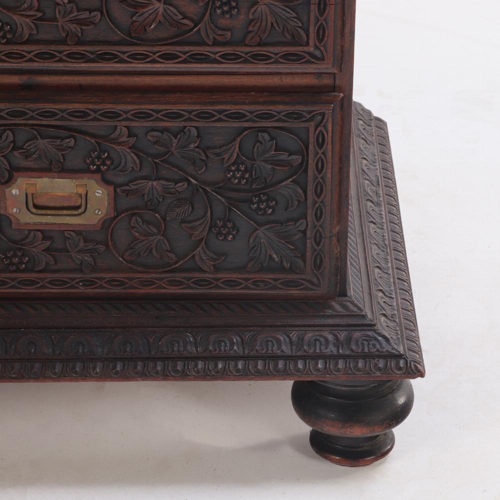 This bookcase is beautifully and delicately carved throughout with scrolling vine and floral designs - on three sides of cornice, frieze, and base molding and the front only of doors and drawers. It is traditionally comprised of three sections - the