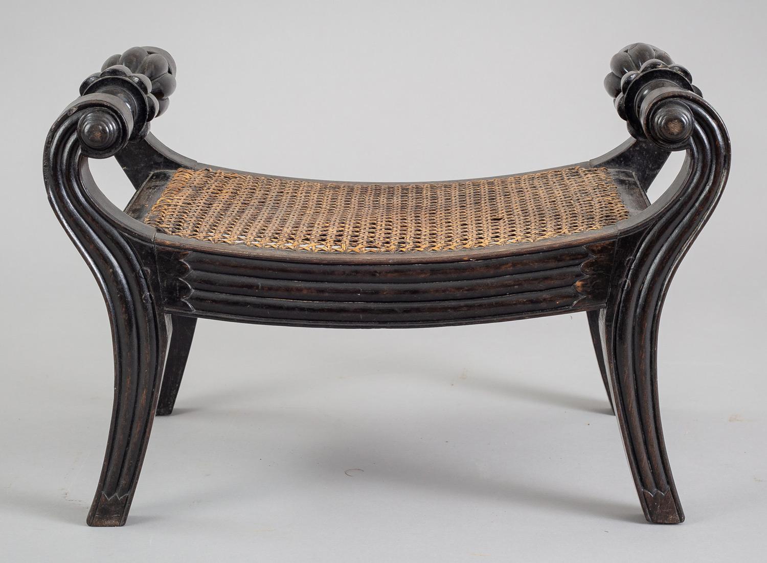 Regency Anglo-Indian carved ebony footstool with beautifully carved handles, caned seat, raised on splayed legs.