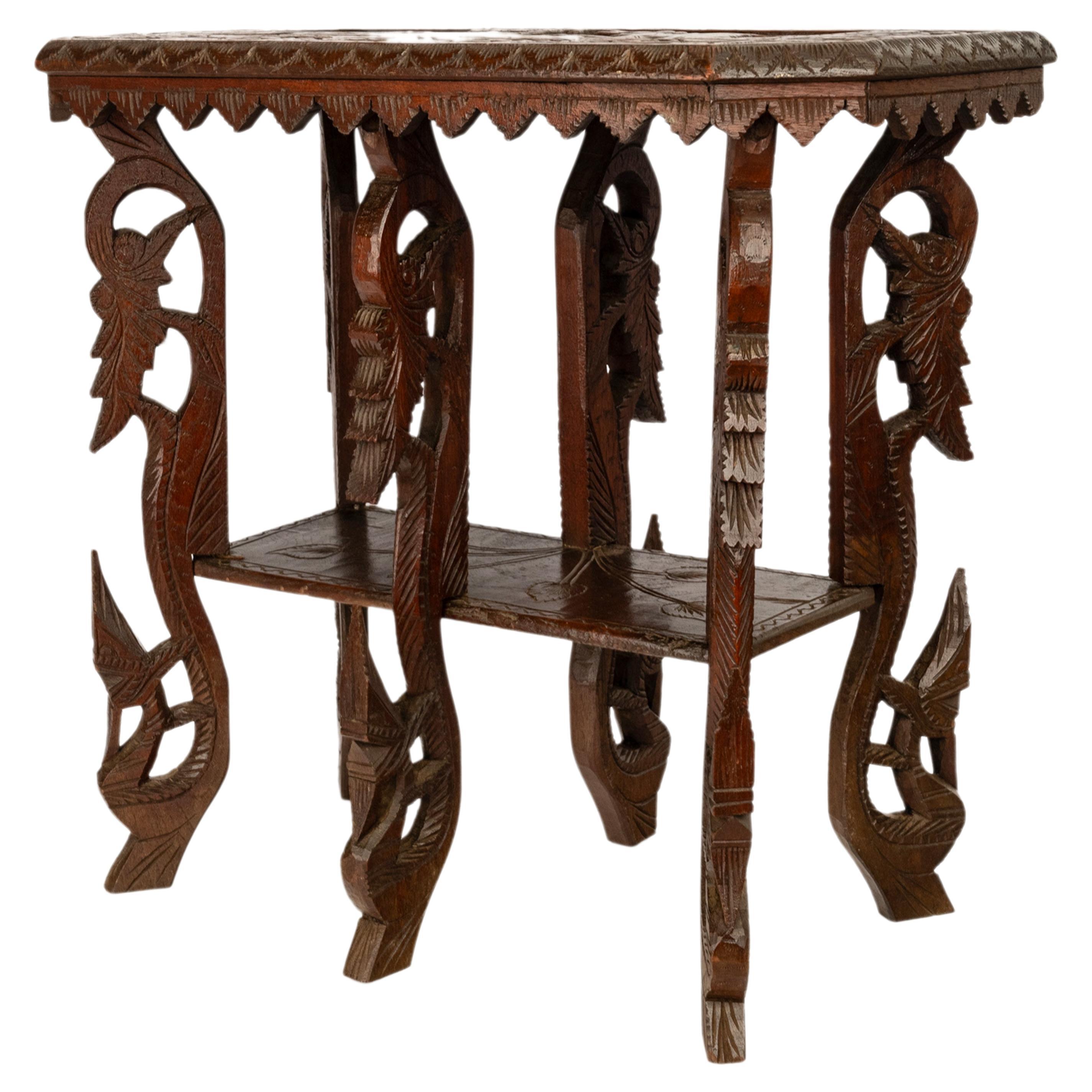 Ein seltener und ungewöhnlicher antiker anglo-indischer geschnitzter Beistelltisch, um 1900.
Der Tisch hat eine seltene Form und steht auf sechs stark geschnitzten Beinen im organischen Stil, die eine untere Etage mit einem indischen