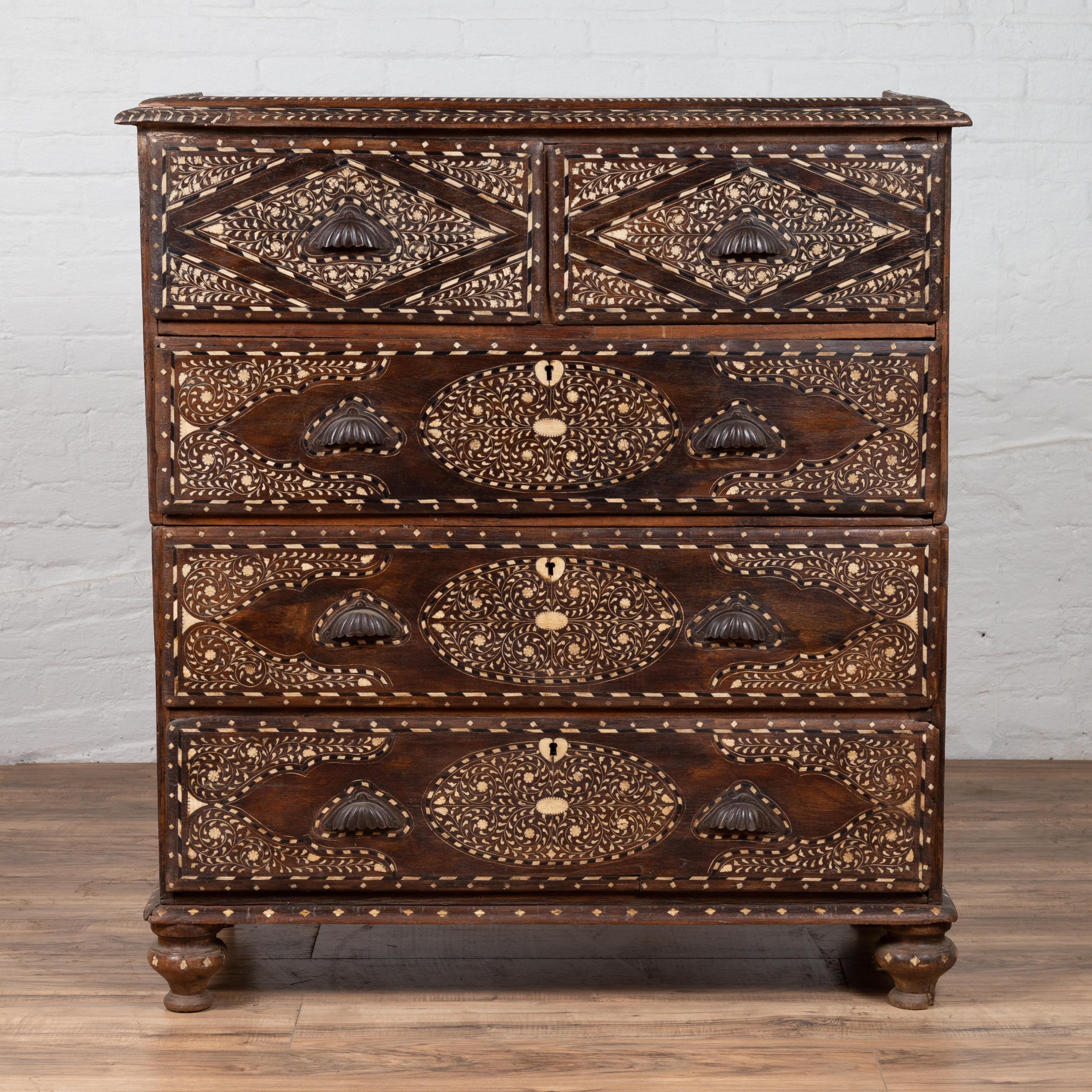 An antique Anglo-Indian two-part dresser from the early 20th century with bone inlay, scrollwork, foliage and geometrical motifs. Born in India during the early years of the 20th century, this stunning two-part dresser features a molded cornice
