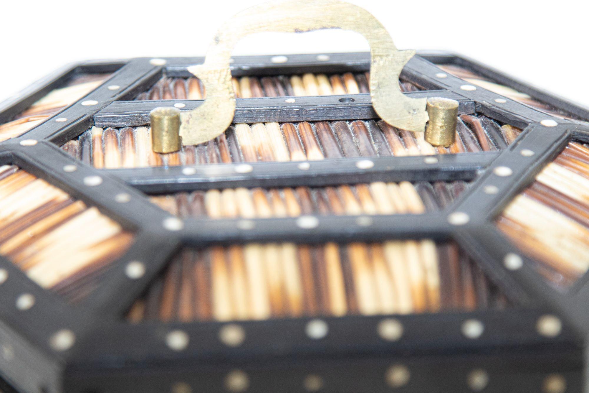 Anglo Indian antique lidded box crafted in hardwood decorated in porcupine quills and bone dots inside and out.
Fine antique Ceylonese hardwood and porcupine quill hexagonal box with bone accents and brass carrying handle, detailed inlay of an