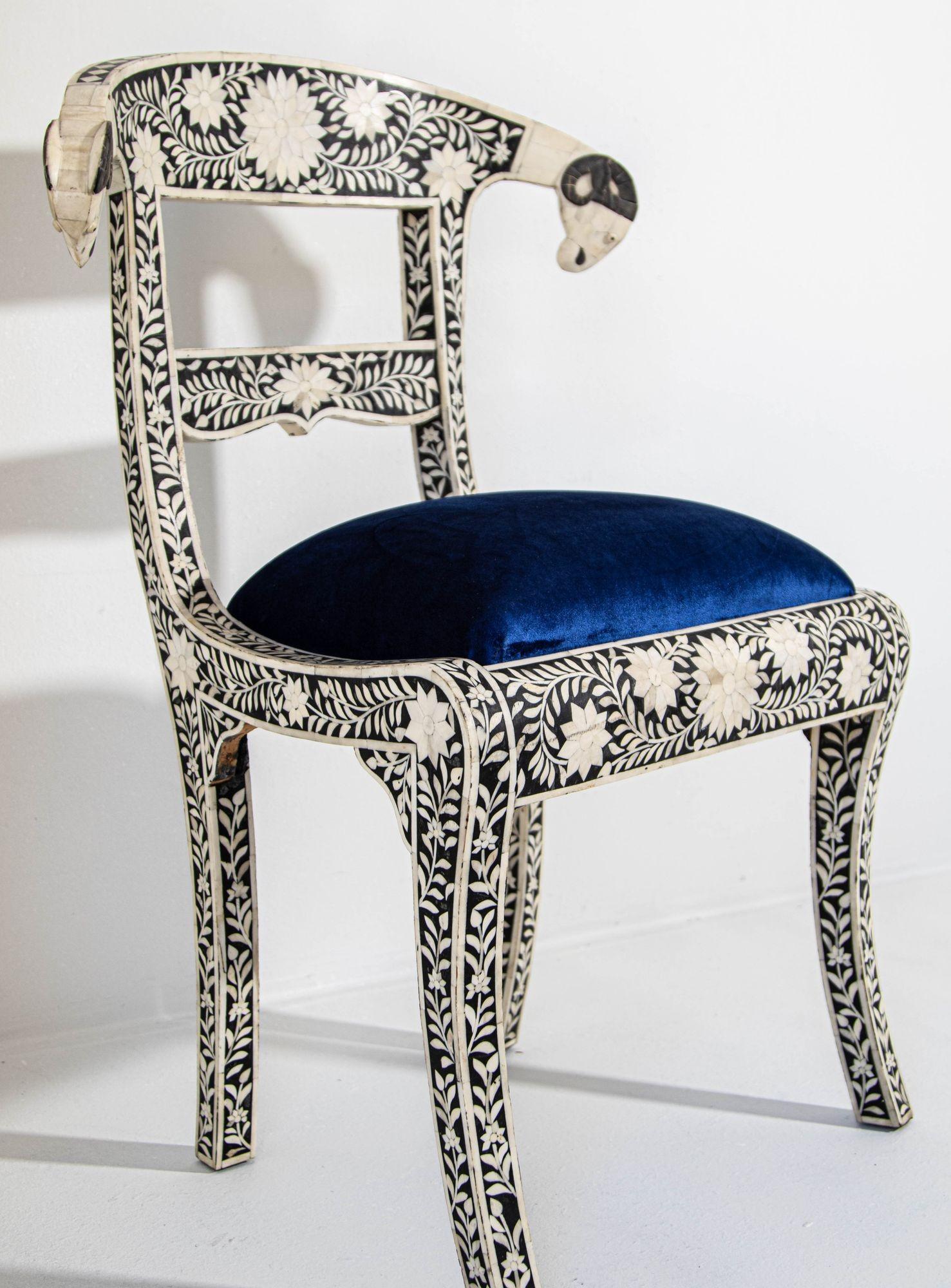 Anglo-Indian black and white dowry side chair with ram's head.
This stunning chair feature a wooden frame inlaid with intricate and detailed floral design in white and black color and scrolling ram's heads finish.
Seat is upholstered in a royal blue