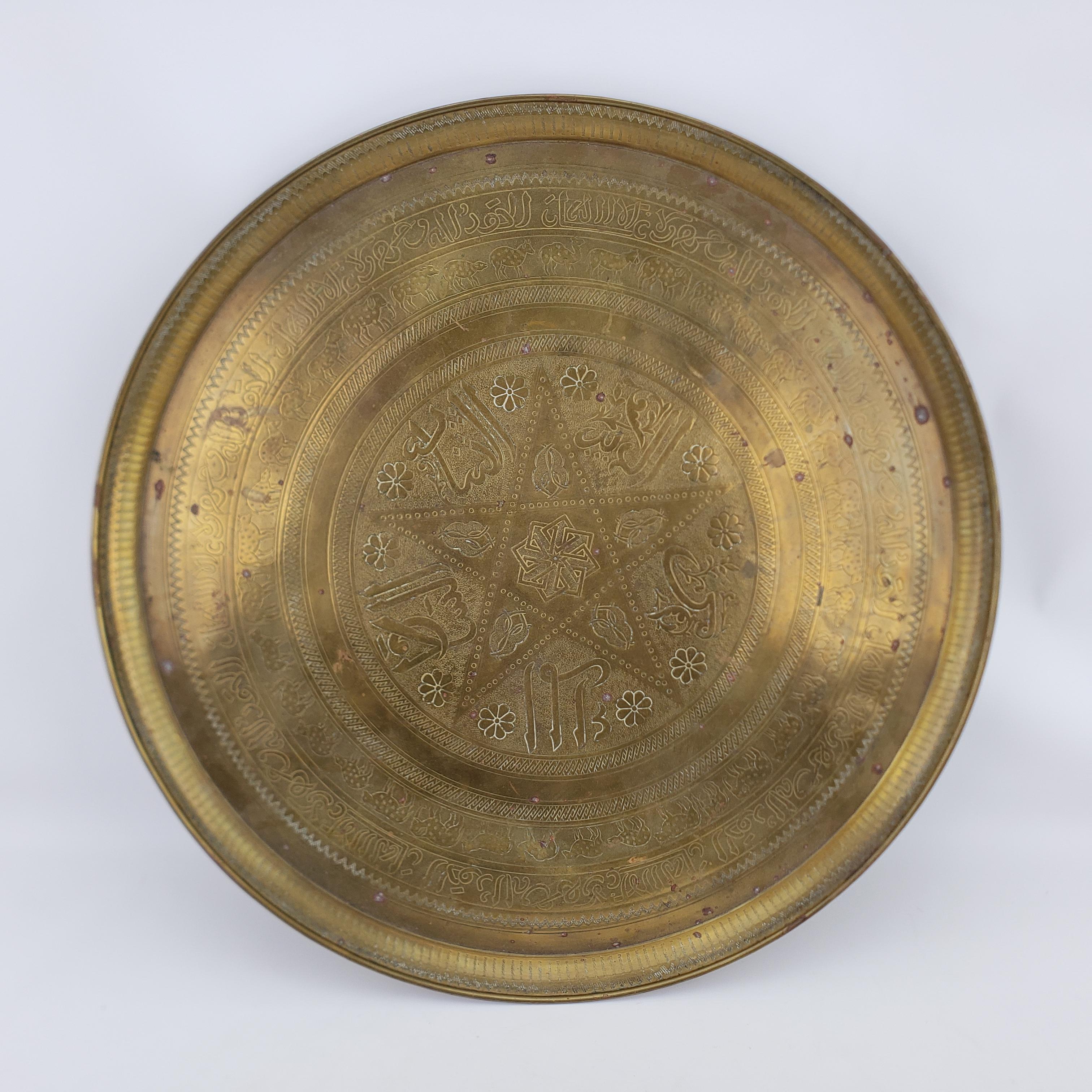 This solid brass tray has no maker's signature, but is presumed to have originated from India and dating to approximately 1920 and done in a traditional Anglo-Indian style. The round brass tray has a central stylized star which is surrounded with