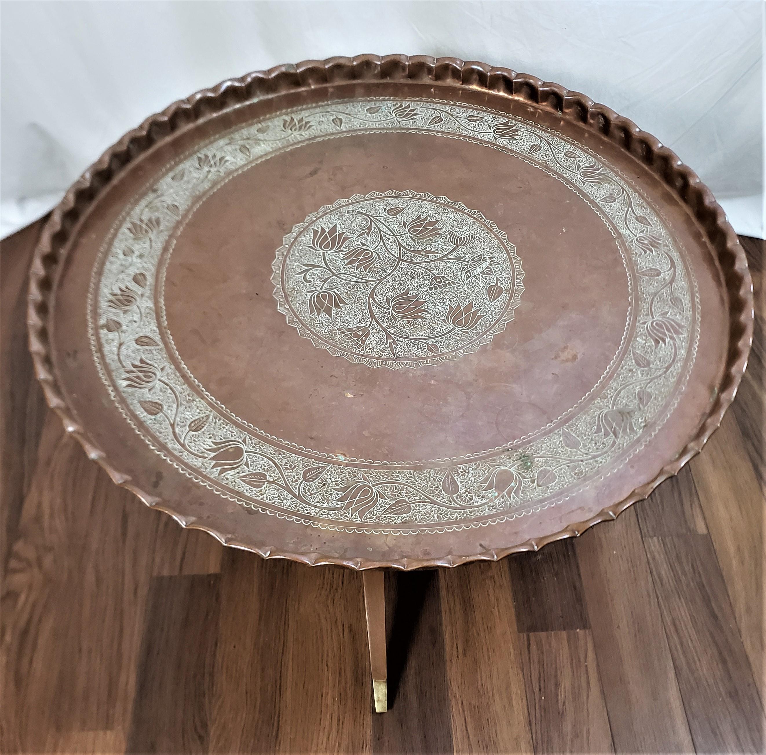 Dieser antike Tabletttisch ist unsigniert, stammt aber vermutlich aus Indien und wurde um 1920 im angro-indischen Stil gefertigt. Das handgefertigte Tablett besteht aus Kupfer mit einem eingravierten Blumenmedaillon in der Mitte und einem