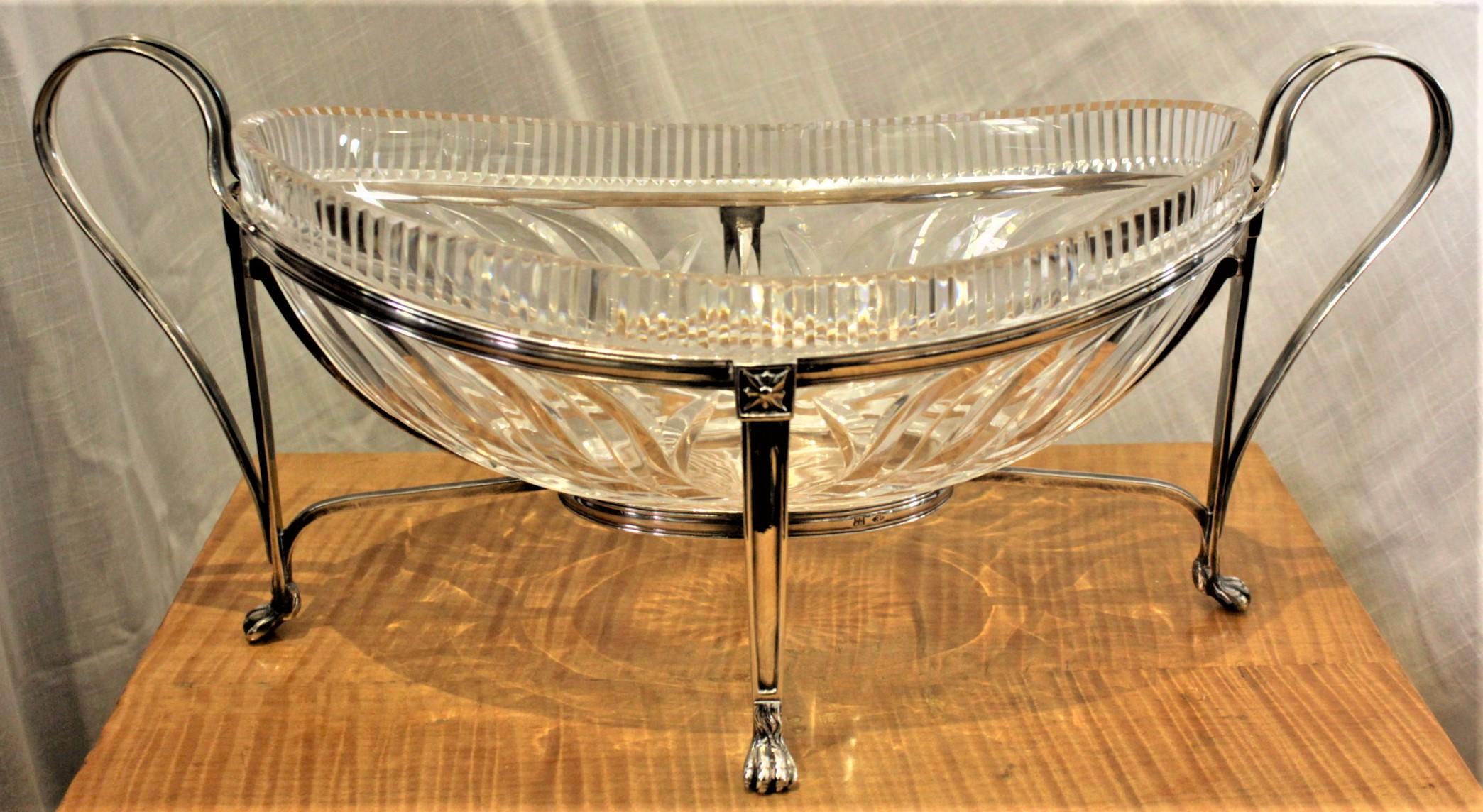 This antique cut crystal and silver plated centerpiece bowl is hallmarked, but the maker is unknown but presumed to be of European origin and was done in approximately 1880. The crystal oval bowl is very nicely faceted around the outside and of the