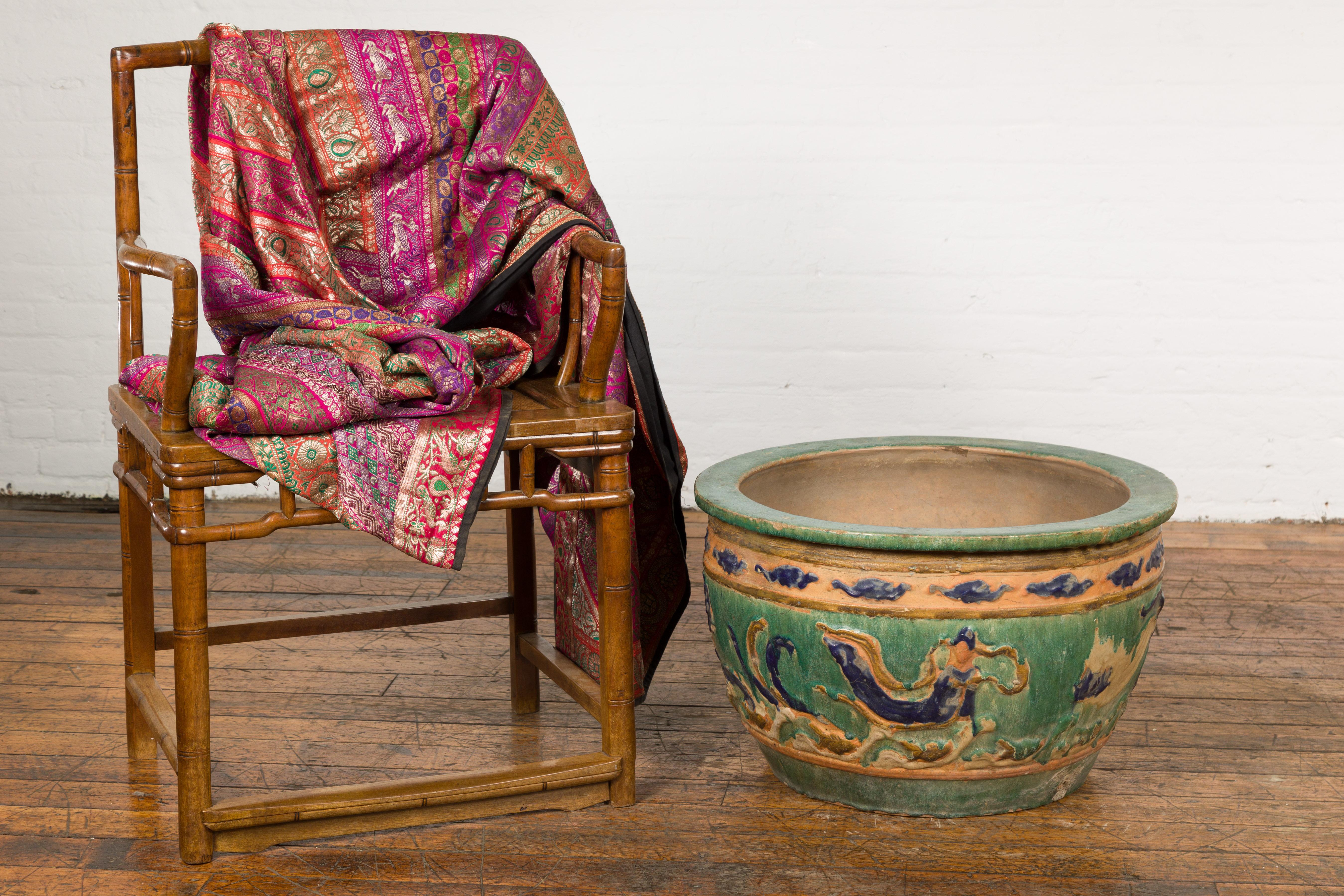 An antique 19th century Annamese green, blue and ocher planter from Vietnam with scrolling decor, clouds, traces of dragon motifs and distressed patina. Handcrafted in Vietnam during the 19th century, this planter features a circular Silhouette